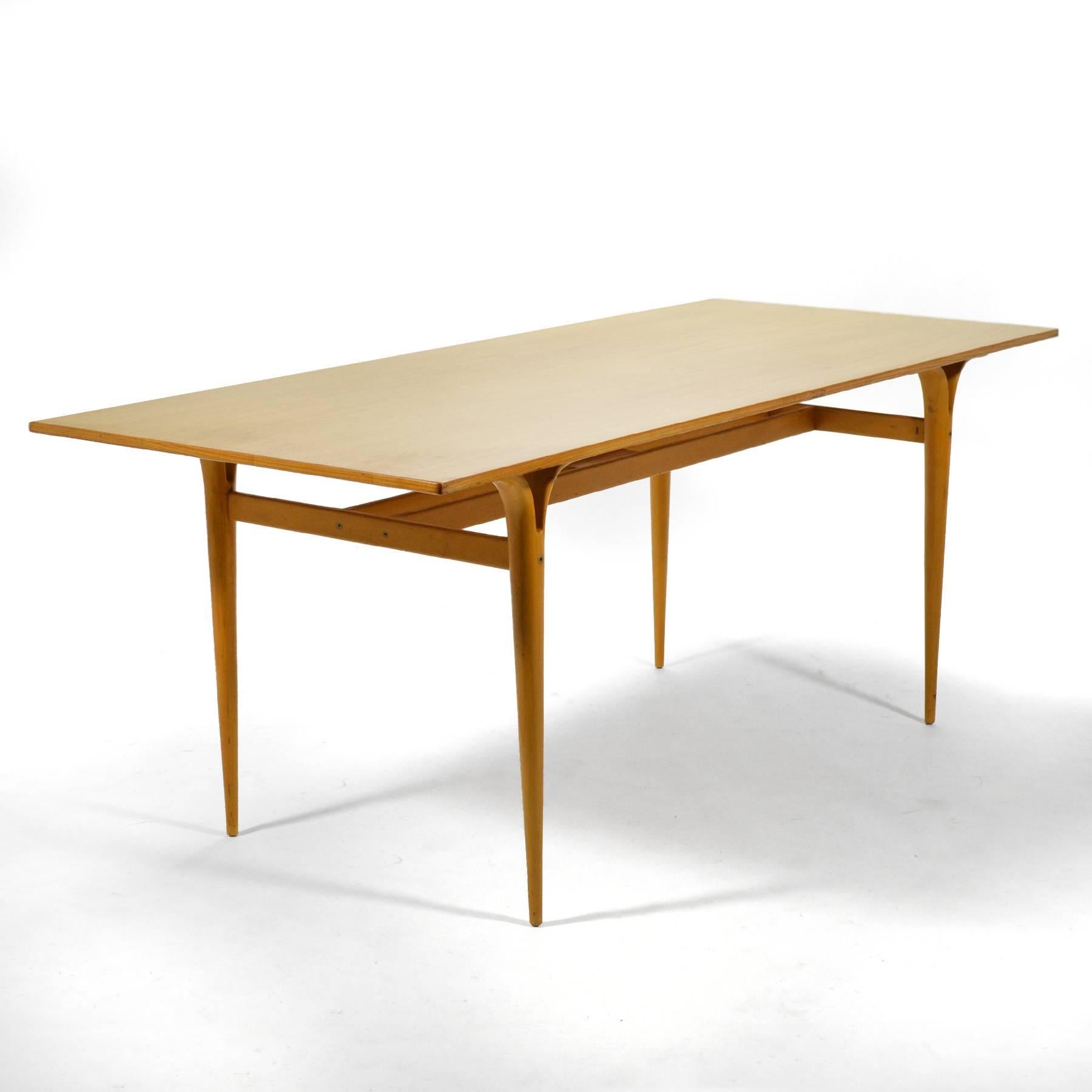 This table by Bruno Mathsson has beautiful sculptural qualities that his designs are known for and is scaled for use as a dining table, work table, or library table. The top of lovely figured ash is supported by a beech base.