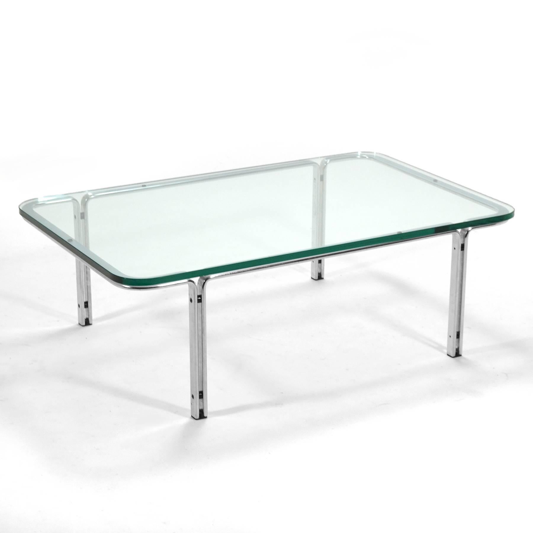 This lovely model T112 coffee table by Horst Brüning for Kill International has a base of finely crafted chrome-plated steel supporting a thick clear glass top with radiused corners which soften the Industrial Design.