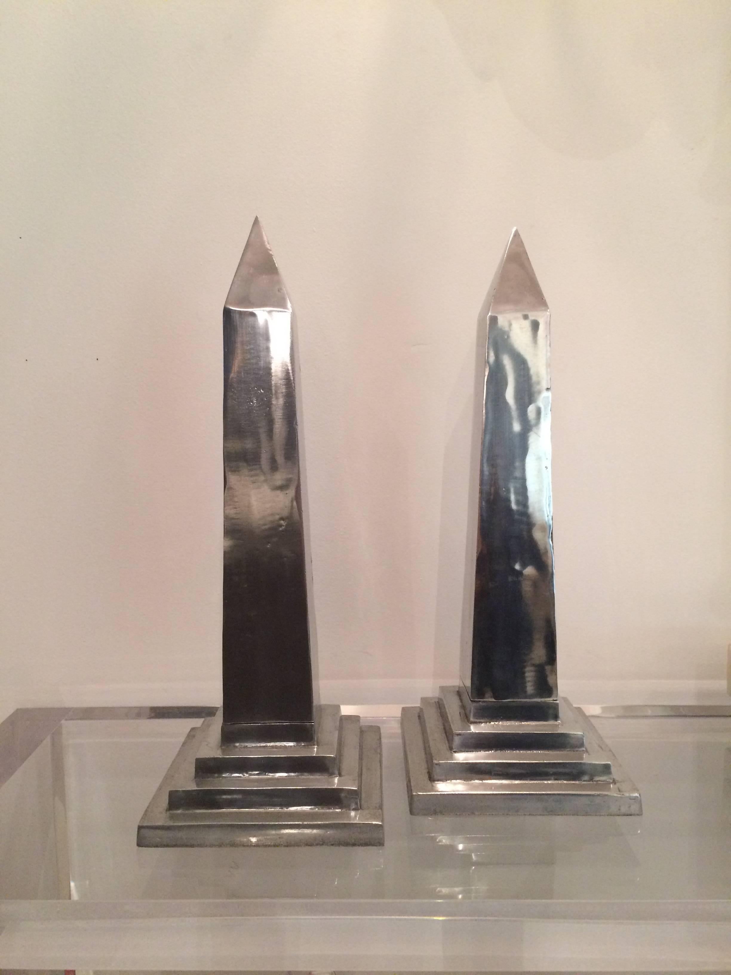 Pair of large polished aluminum obelisks by Arthur Court, with stamped signature on underside. Stepped base is made as separate piece, and is screwed into place. Some pitting and wear, but generally smooth and polished overall. Great scale!