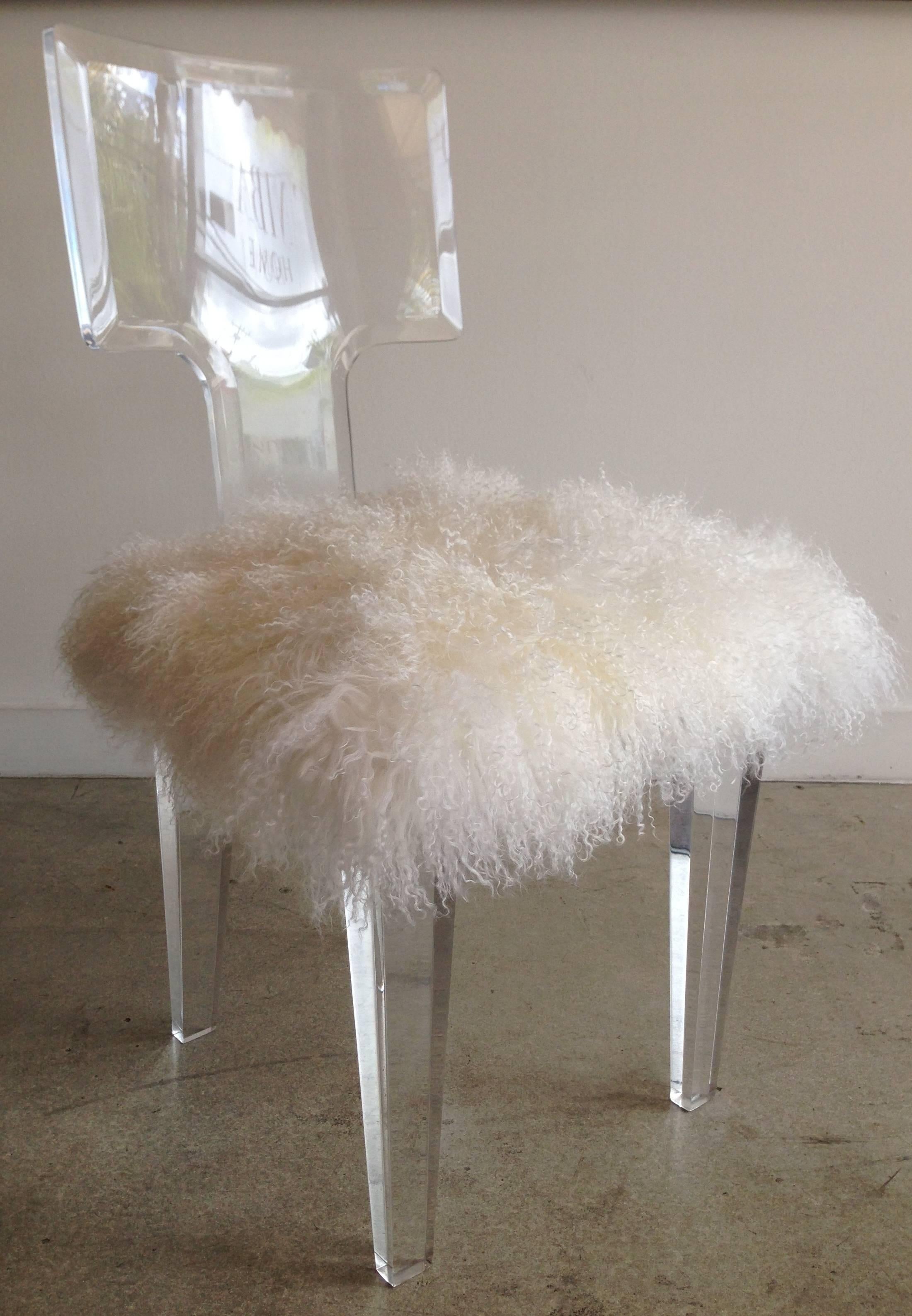 Clear Lucite chair with tapered legs, upholstered seat in white Mongolian lamb.  

Also available COM, requires 1/2 yard plain fabric, $1225.