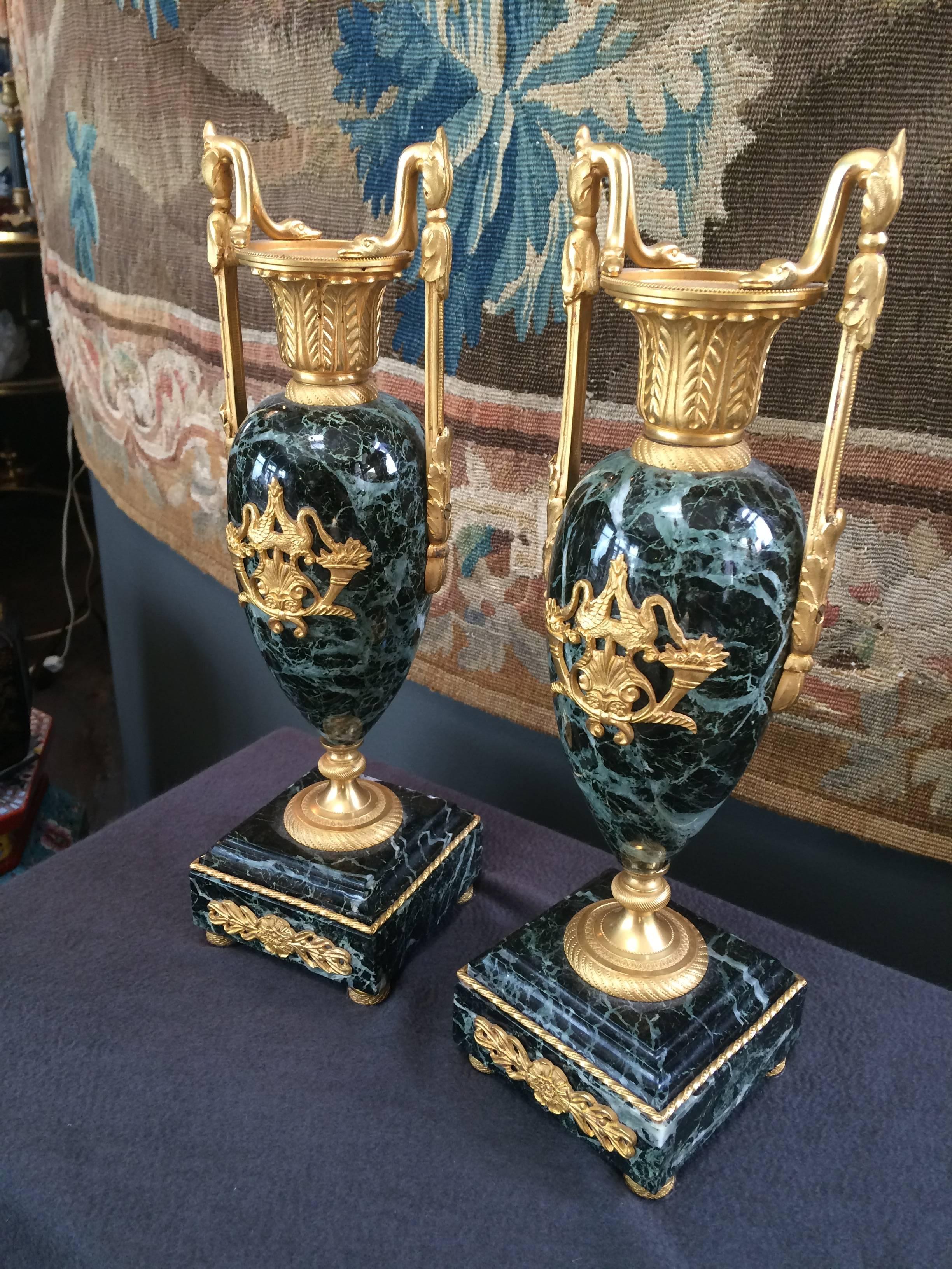 A charming pair of polished verte marble and bronze doré cassolettes, double handles with snake motif on rim of candleholder opening with acanthus detailing throughout and front mounting of long neck swans with floral and shell detailing, 19th