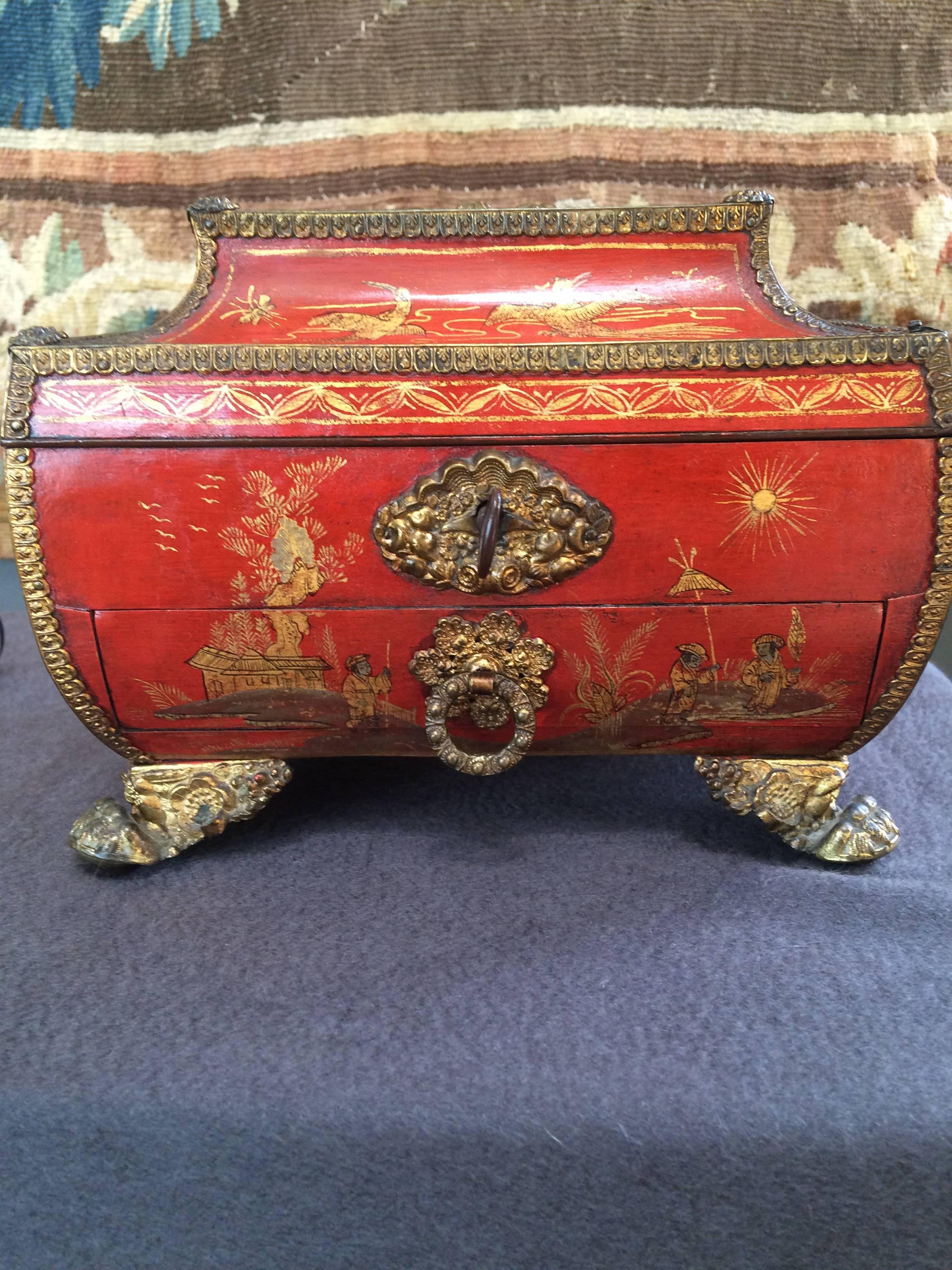Beautiful small red lacquered chinoiserie sewing box with ormolu mounts
with finely detailed figural and landscape designs in gold, with lock and key.

Continental