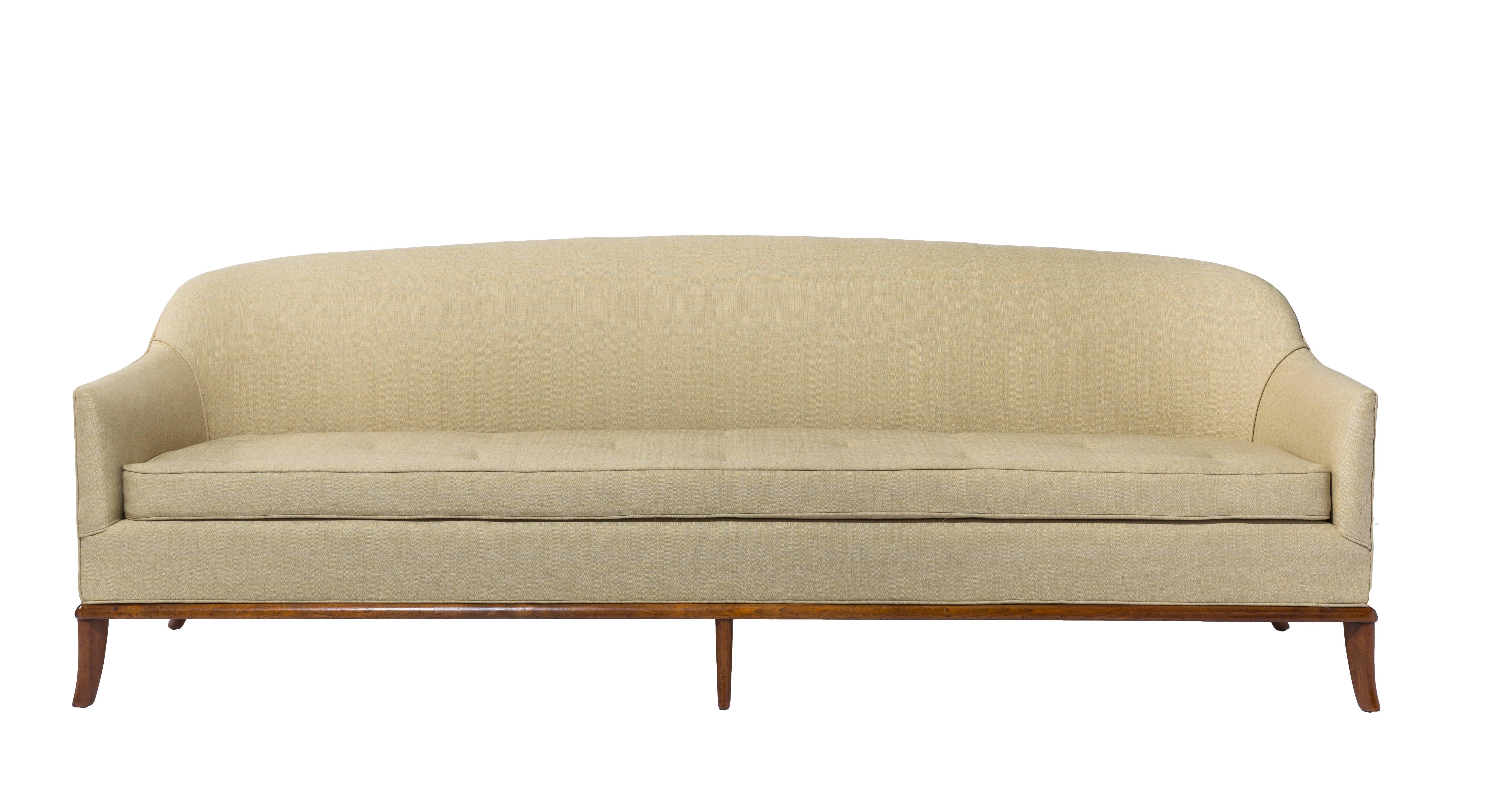 Long and elegant 7.5 Gibbings curved back sofa on a six sabre legged walnut base and manufactured by Widdicomb. Recently reupholstered and with a refinished base. A rarely seen design from Gibbings.