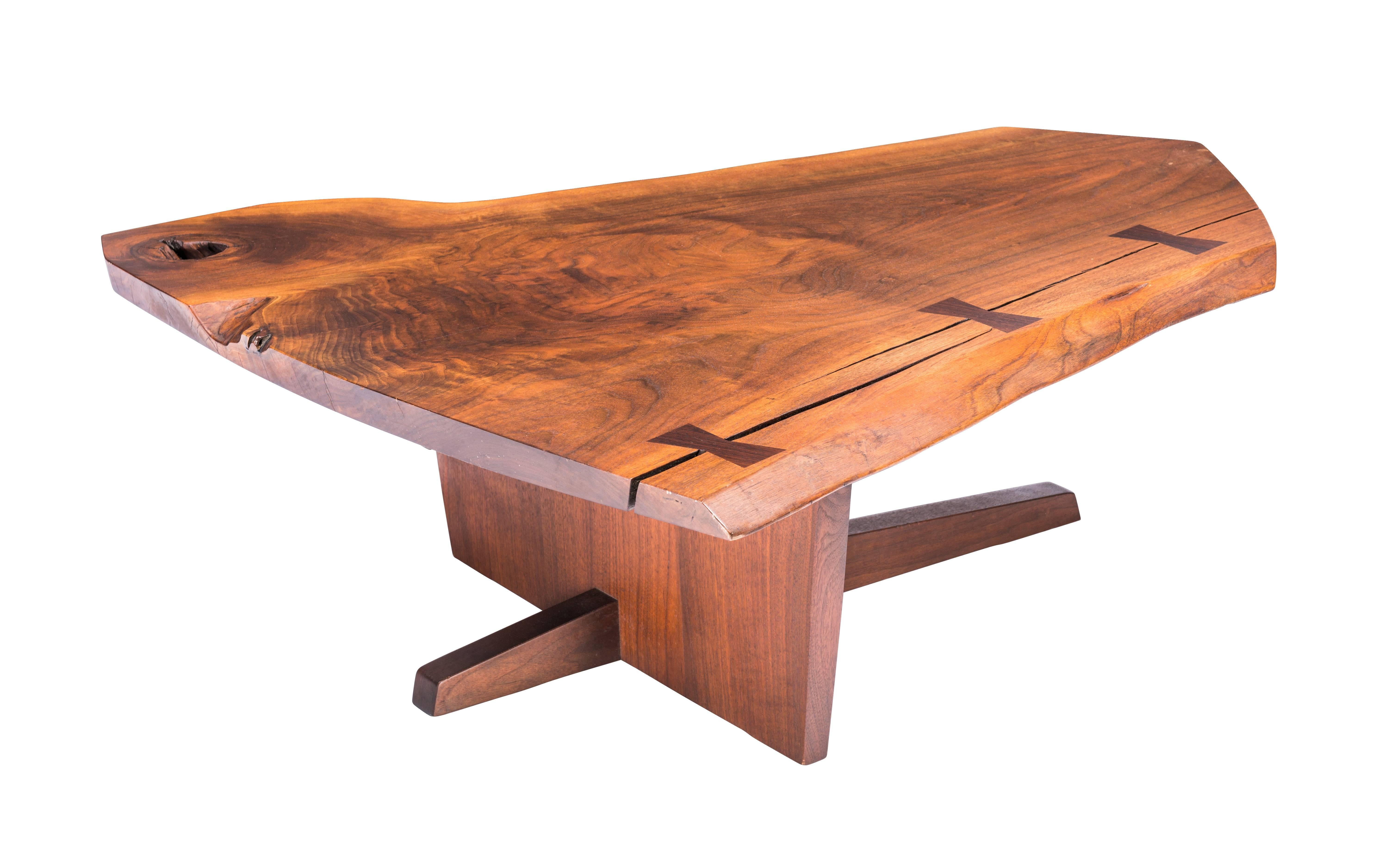 
Exceptional Nakashima walnut coffee table atop a rare Ming II base. Nice expressive top with sap edge and a crotch cut edge. Top also with a holes three butterflies connect two wood splits. Signed and dated 