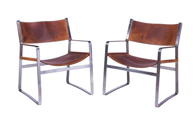 Very rare and well-constructed pair of Wegner Model JH 812 lounge chairs in chrome-plated steel with original saddle leather, circa 1970. Documented in Hans J. Wegner's 100 Chairs, Oda, pg. 191. Nice natural patina to leather seats and backs.
