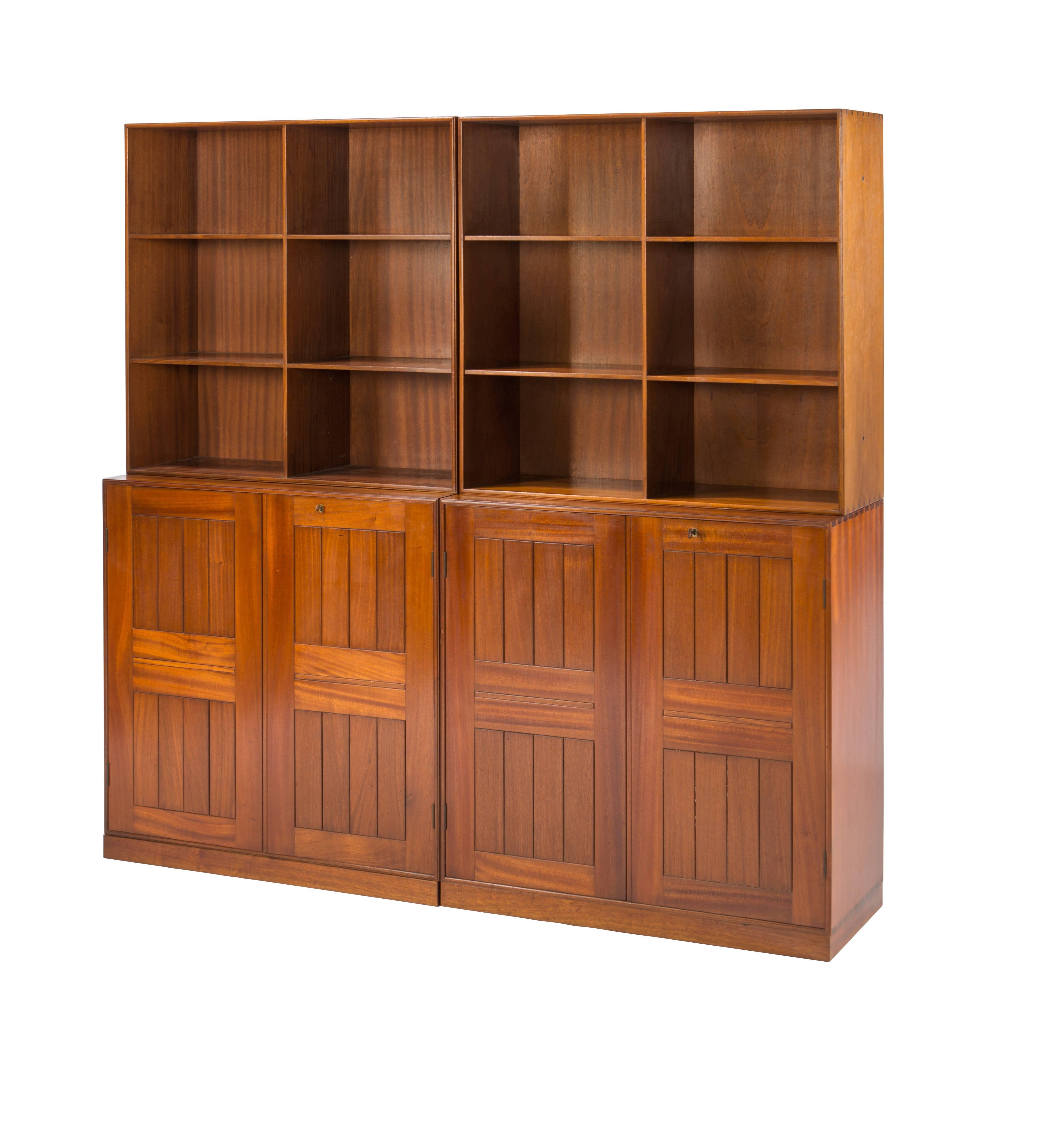 Great set of Mogens Koch bookcases in Cuban mahogany. Four piece bookcase with two cabinets with multiple interior storage and two open bookcases. All pieces have dovetailed joinery. The cases also sit on small separate plinths. With labels to back