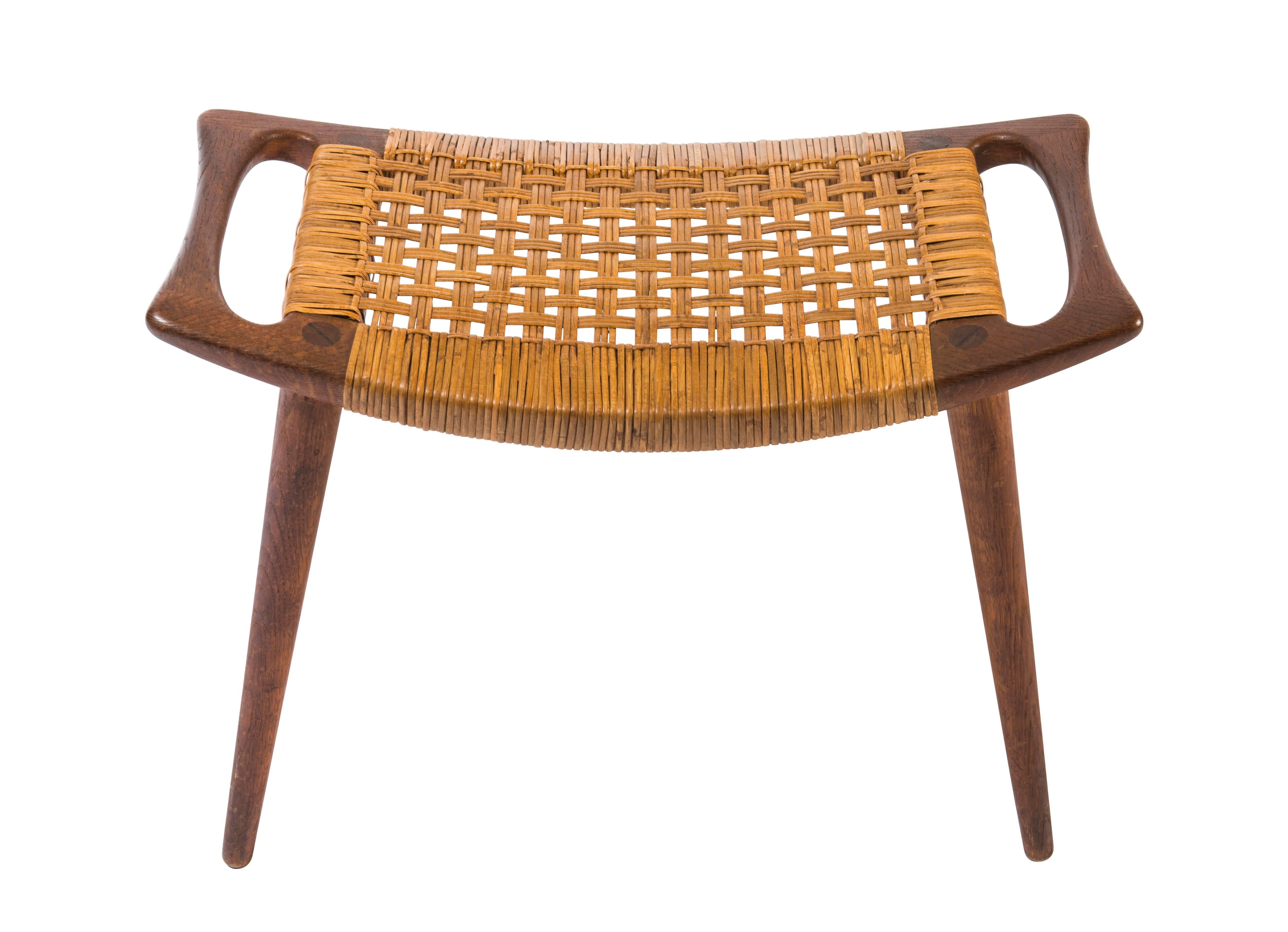 Early teak and caned stool or ottoman from Hans Wegner for Johannes Hansen. Original cane with original label.