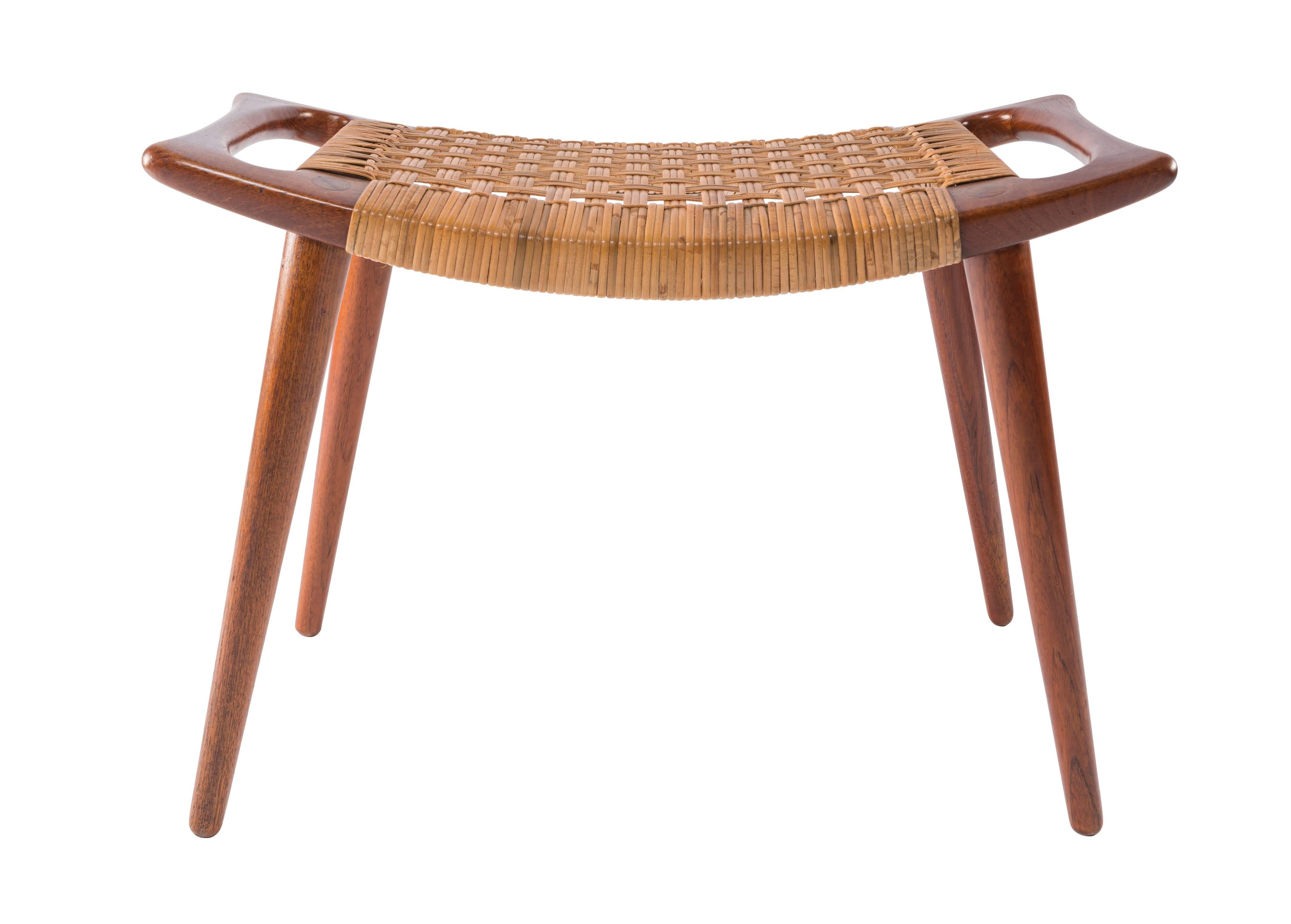 Early teak and caned stool or ottoman from Hans Wegner for Johannes Hansen. Original cane with original label.