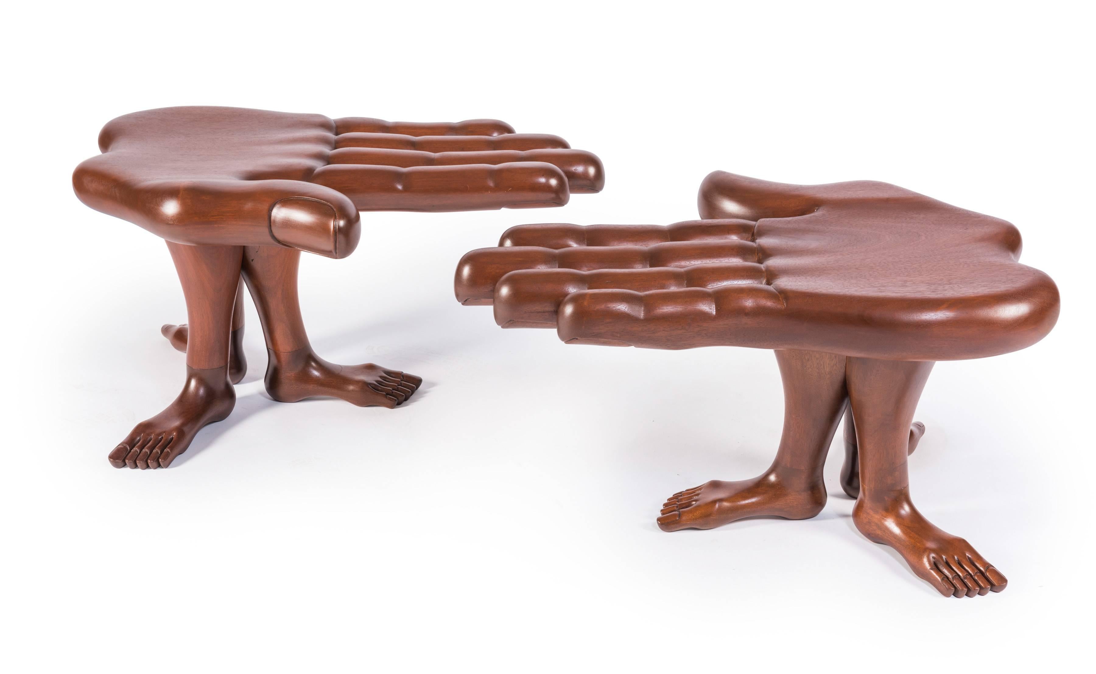 A rare pair of hand and foot tables or stools designed and made by Mexican Surrealist artist Pedro Friedeberg in his iconic hand and leg motifs. Made of laminated and blocked mahogany, this pair features a palm supported by three legs with with