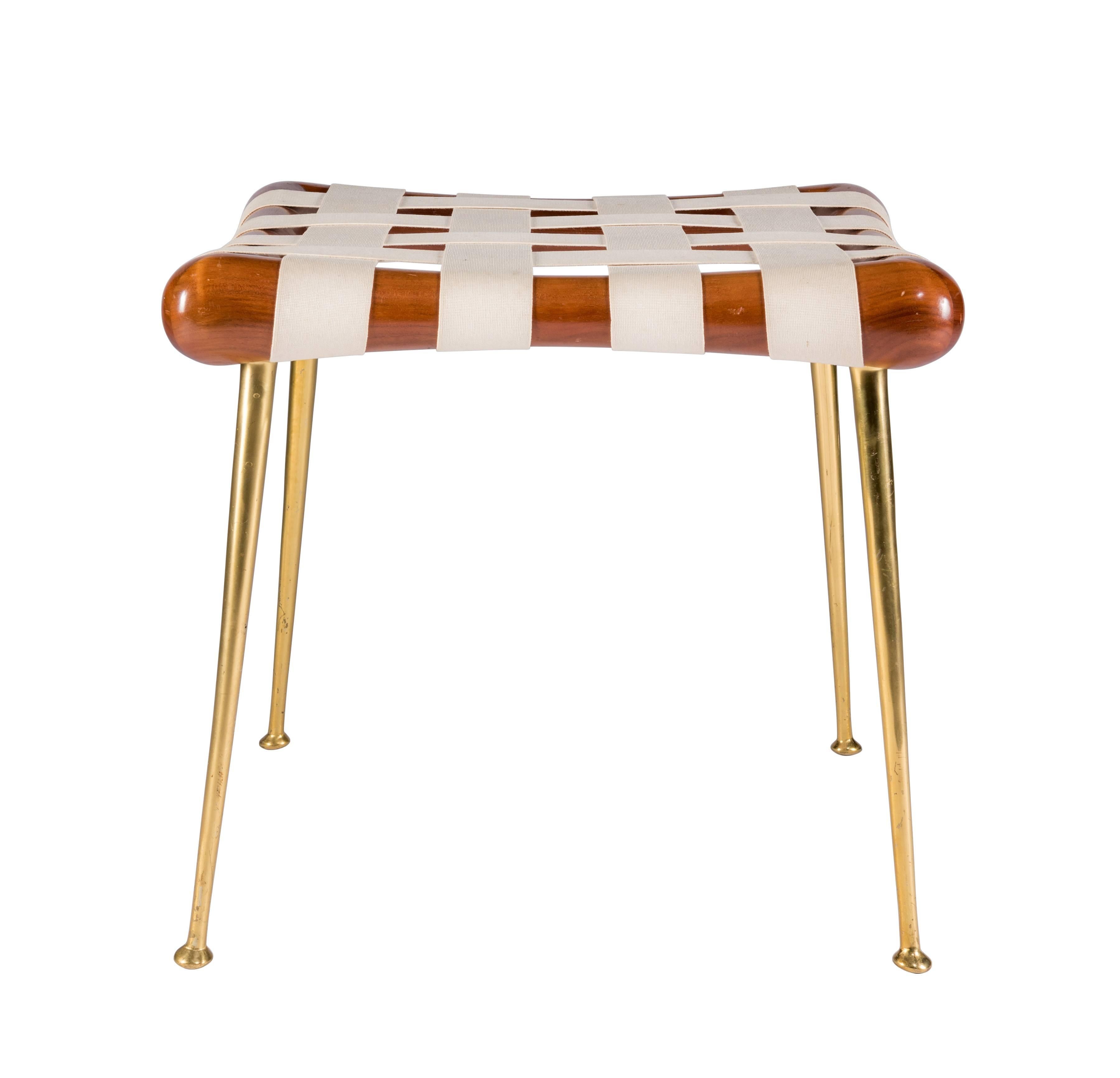 A rare and elegant stool designed by T.H. Robsjohn-Gibbings in 1957. This very clean example was manufactured by Widdicomb for a short time and features a walnut frame atop tapered brass legs. Model No. 1730.
        
