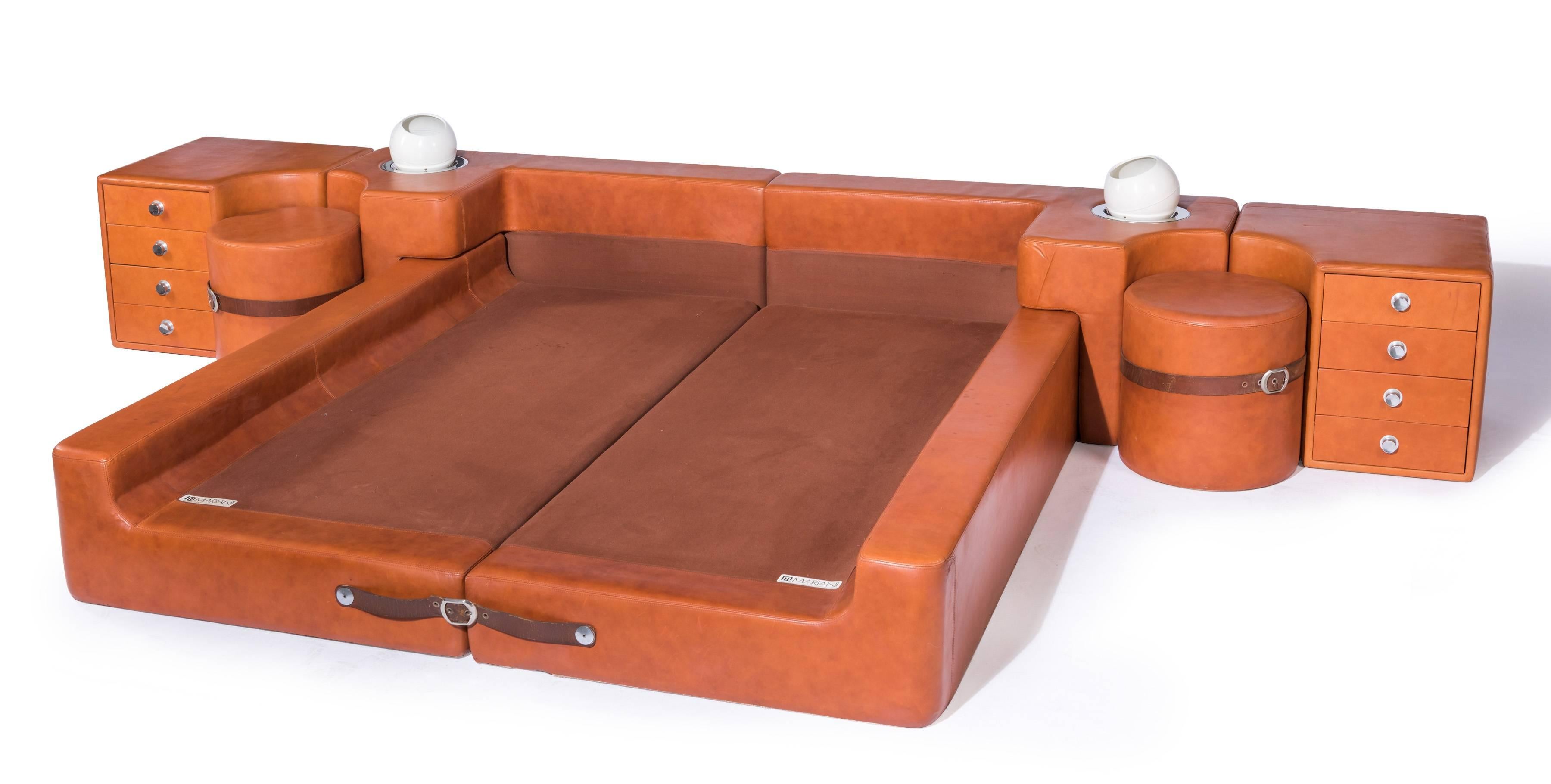 Cognac leather bedroom suite by Guido Faleschini for Mariani of Italy, circa 1975. This Italian bed includes bed frame with headboard, two nightstands and two built-in lamps. The frame is held together by a leather belt. Similarly, the two circular