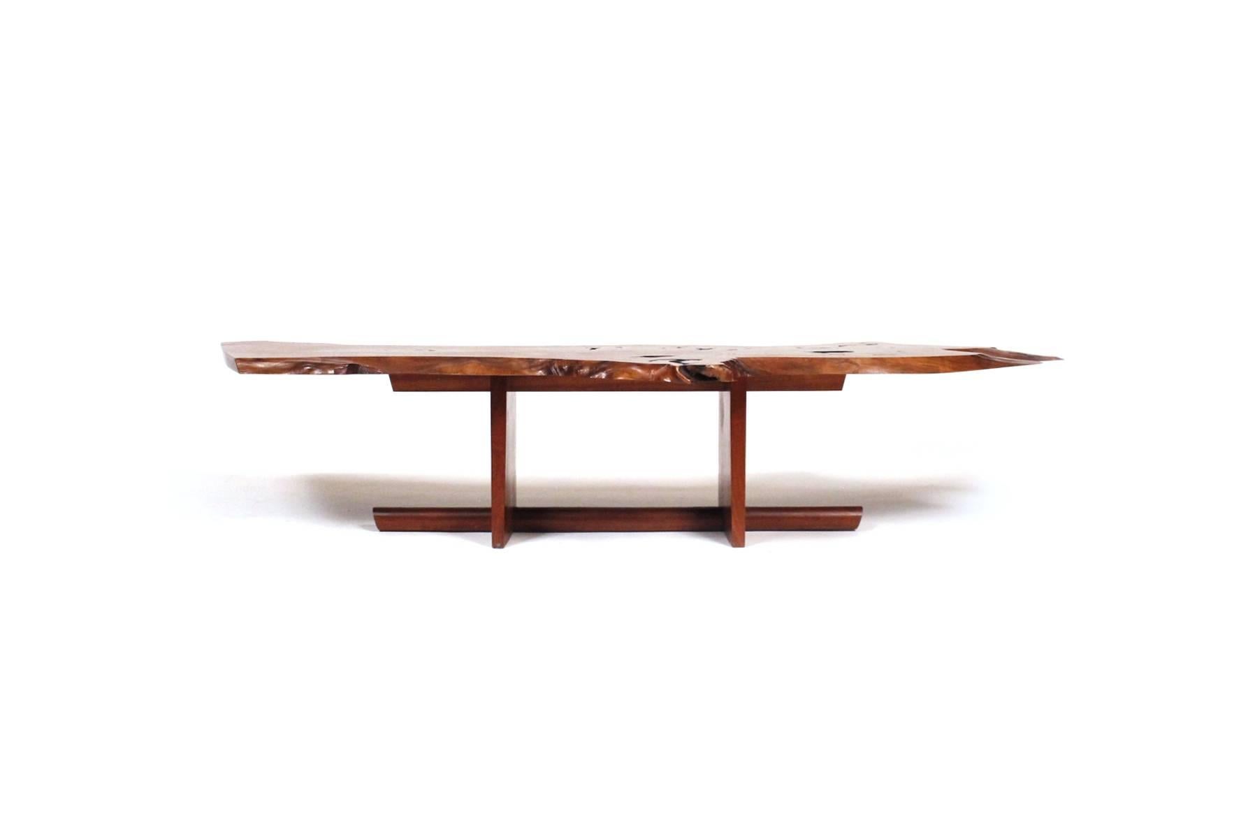 Exceptional and large George Nakashima coffee table in American black walnut and executed in 1970. Beautiful and highly expressive l single-slab top with a continuous free-edge to three sides. Top with numerous fissures, knot details and holes. Base