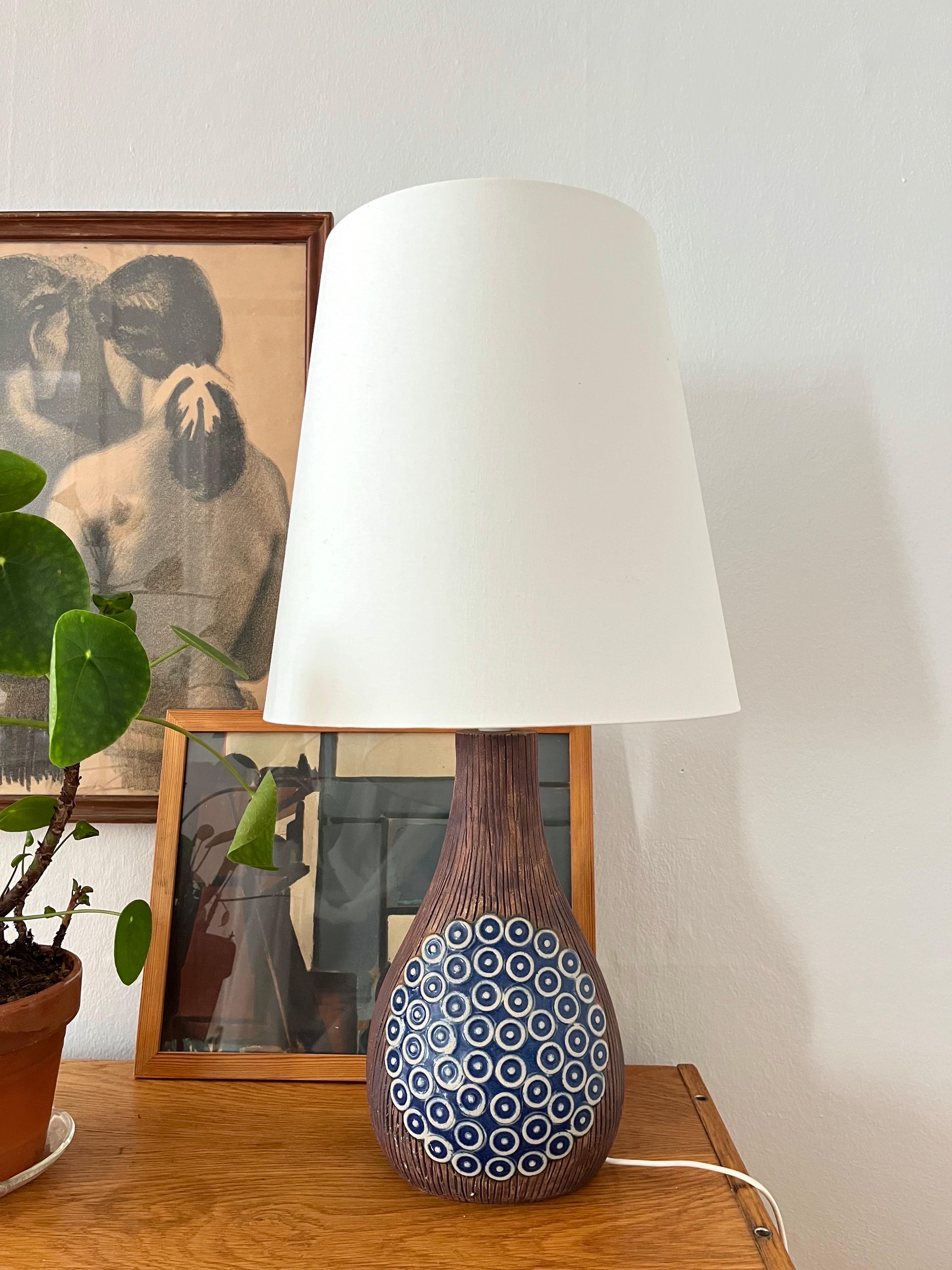 Lampada da tavolo in ceramica decorata degli anni '70 della svedese Ego Stengods.
Realizzata negli anni '70, questa lampada da tavolo in ceramica opaca presenta una decorazione lucida in blu e bianco su entrambi i lati. Realizzato da Ego Stengods in