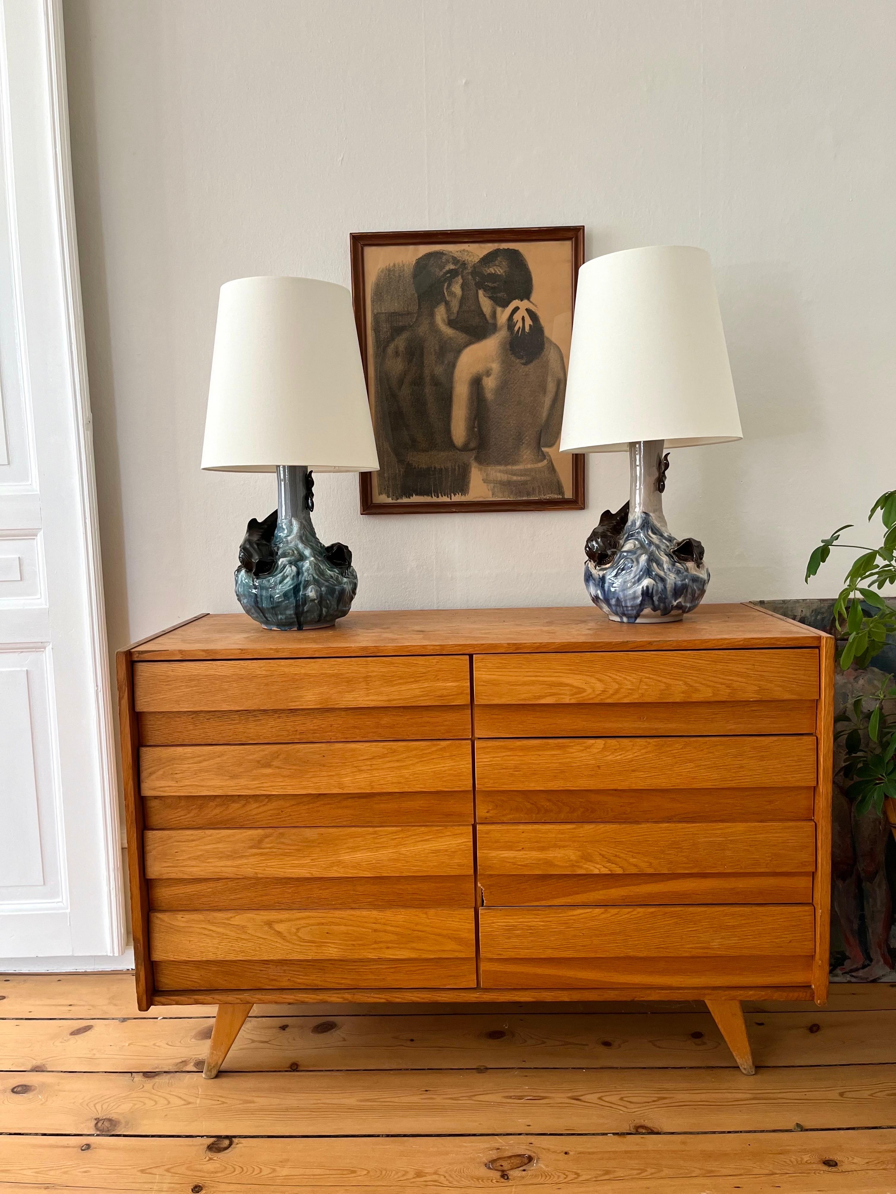 This rare pair of Danish ceramic table lamps are designed by Hans Ancher Wolffsen (1870-1929) / Søholm and is exhibited at Bornholm's Museum. Highly decorated and with a glossy glaze and sculpted fish in a roaring sea, this design was made around