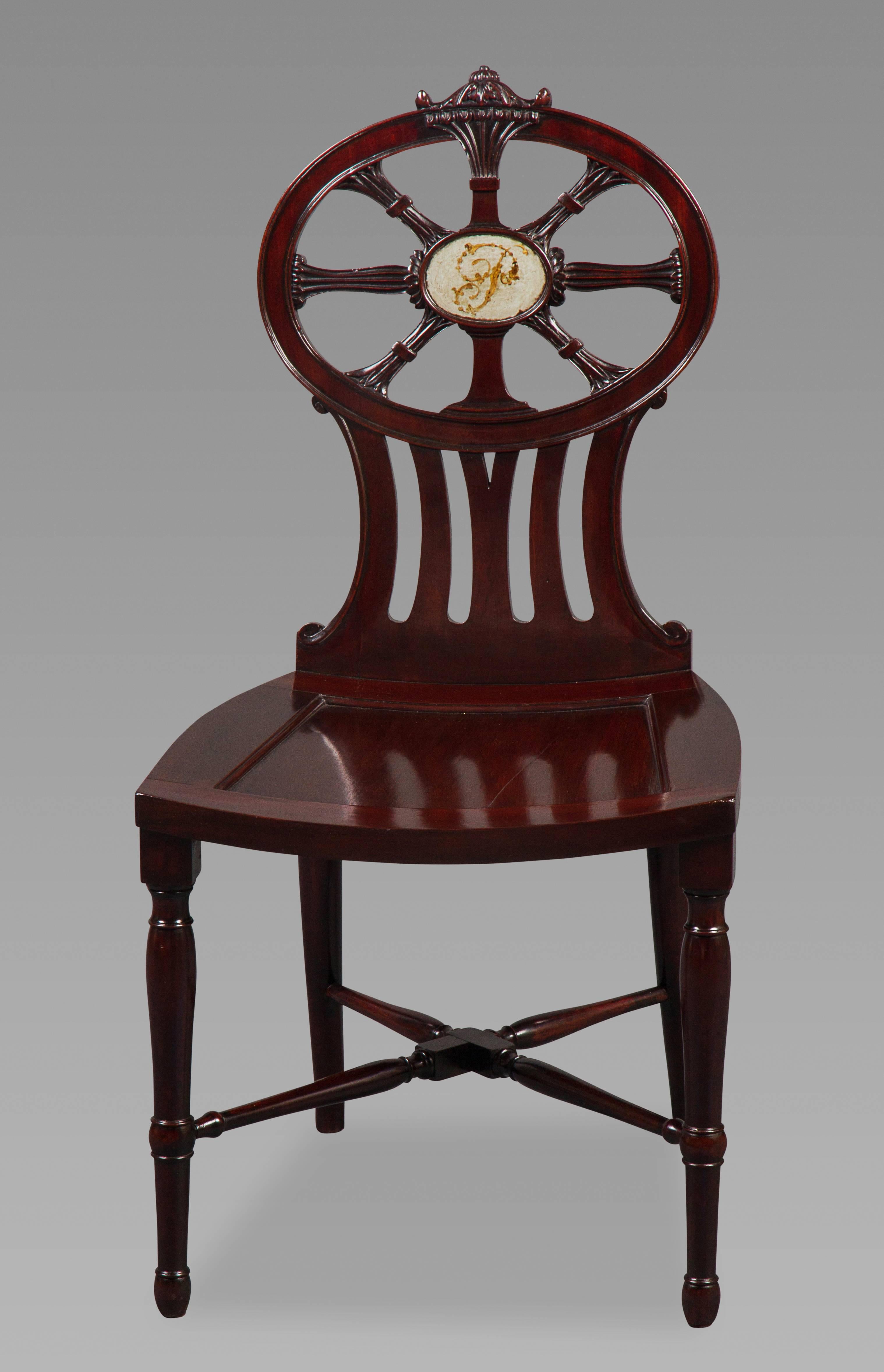 The four chairs of the finest quality mahogany, the backs with an oval six spoked compass design centered by an oval plaque painted with a floral 