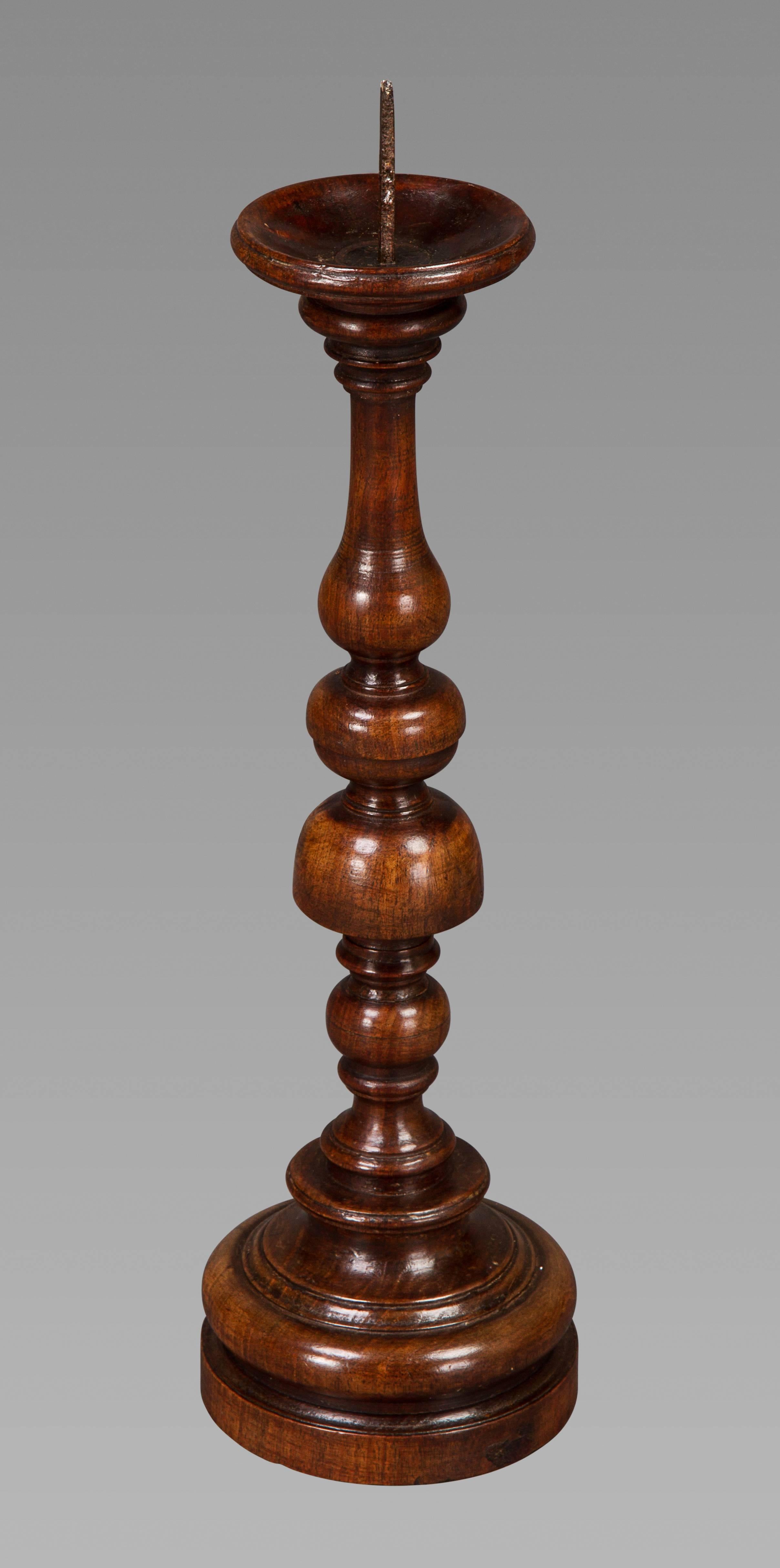 A wonderful pair of oversized walnut candlesticks with the original iron spikes centering dished drip trays above ball and inverted cup knopped turned stems over lead weighted bases, with great colors and surface.

 