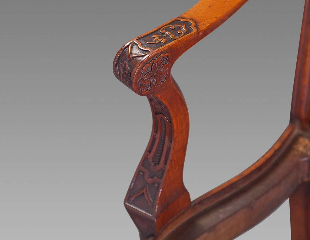 Overall in a robust Chinese Chippendale design, the double chair backs with scrolled, fluted and foliate carved crest rail above fluted stiles and intricate lattice work carved and pierced central splats. The outward curved foliate carved arms above