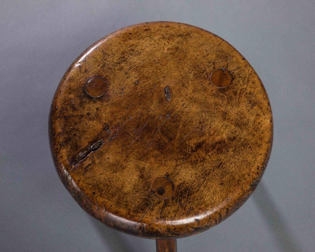 A fabulous rustic stool with a two inch thick sycamore seat morticed through and wedged with ash legs. The seat with wonderful color and patina.

English, circa 1800.