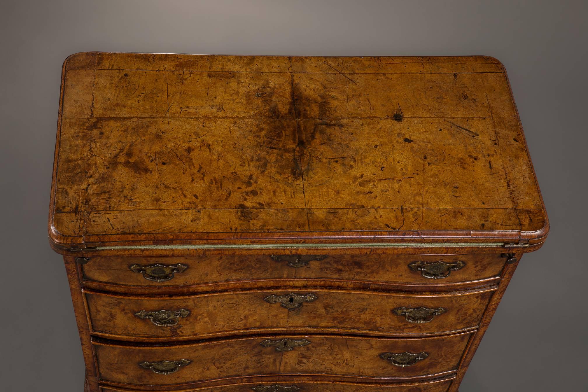 An exceptional bachelors chest of magnificent color and patination. The top quarter veneered in the finest burr walnut opening to a green velvet lining and revealing a lockable panel to an interior well reminiscent of case furniture of the 1690s.