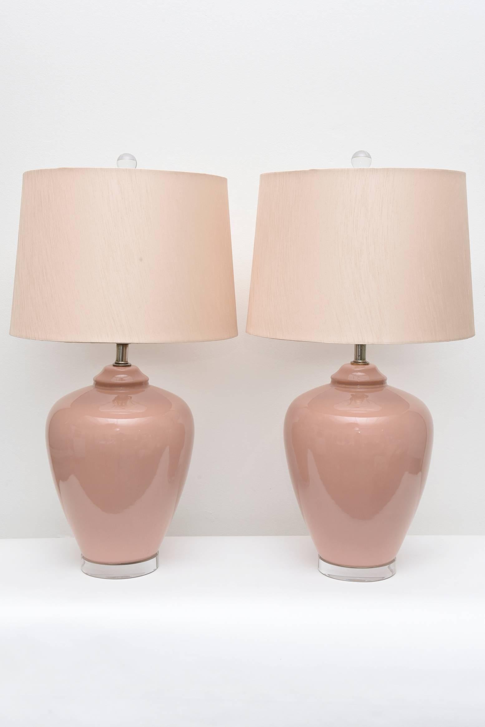 Pair of vintage pink Italian ceramic table lamps. Classic urn shape in a lovely pink color. Recently rewired for US standards. Refinished with a clear Lucite base.