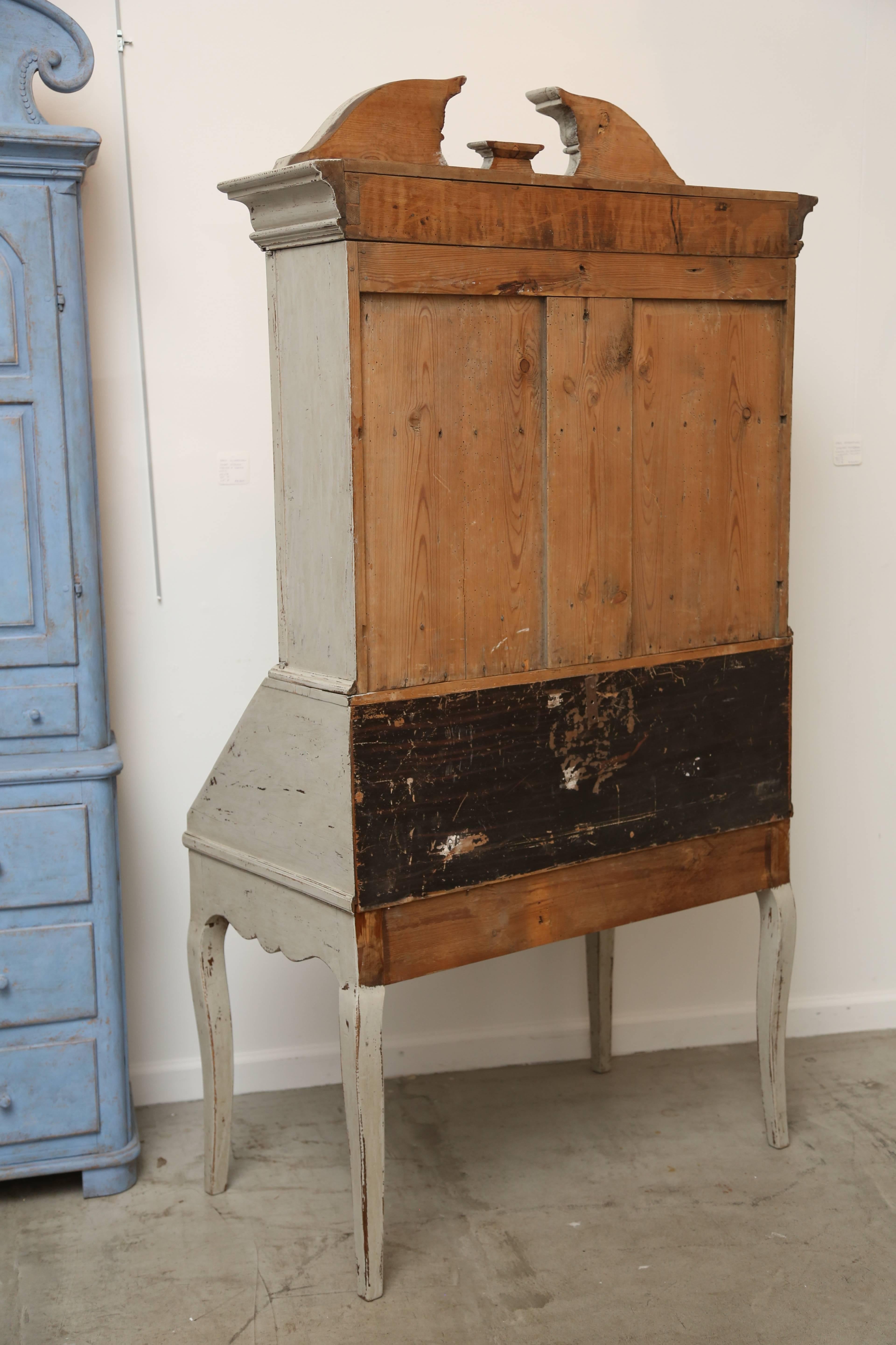 Antique Swedish baroque secretary display cabinet late 18th century

The Secretary is in two sections, painted in a lovely Swedish distressed gray color.
The upper section has an impressive arched cornice with opening in the center
and a vase shape