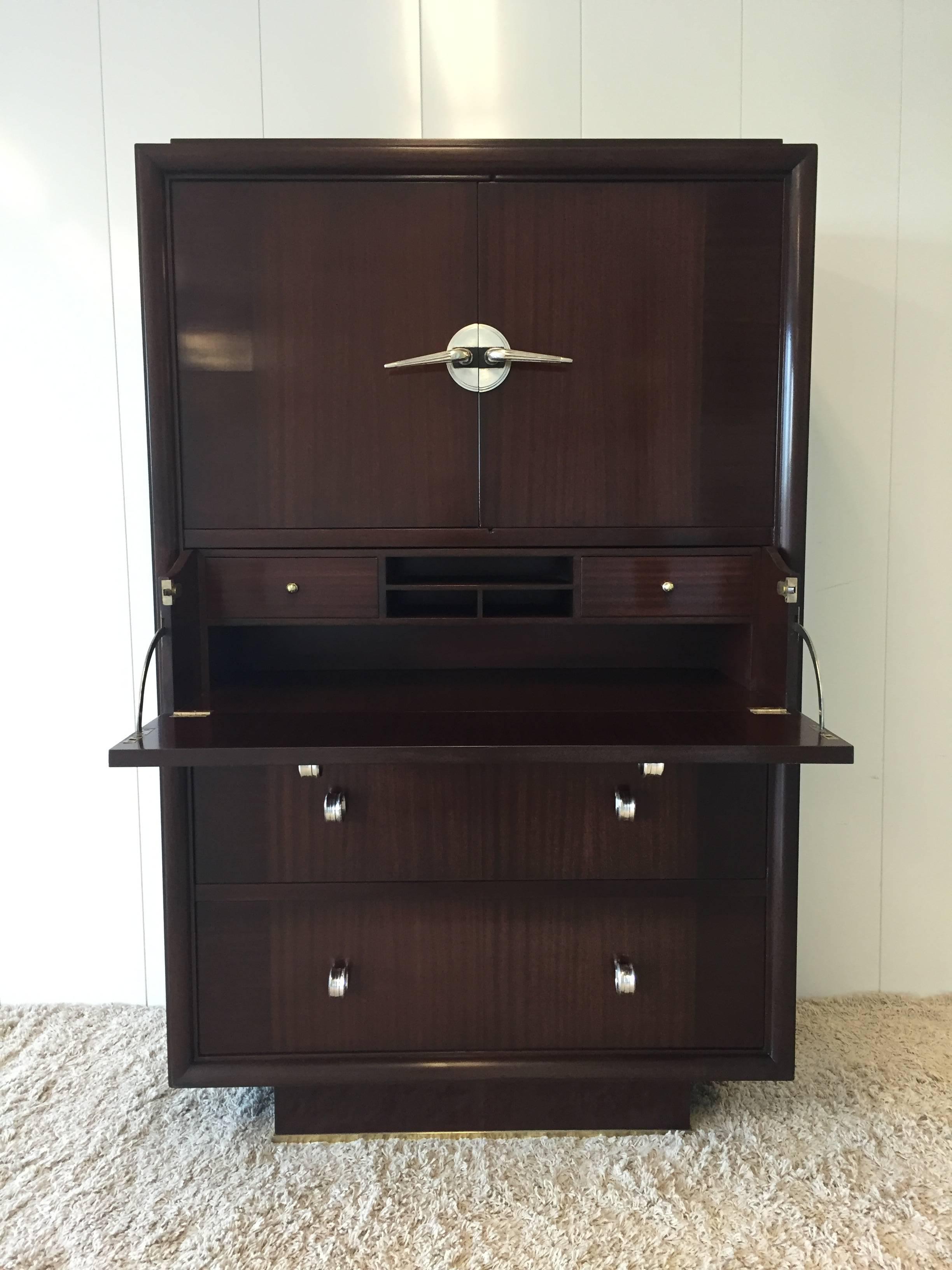 In the style of Donald Deskey, Art Deco skyscraper design, cabinet/secretary desk, with draw compartments and desk, book shelf compartment. Functional dark mahogany wood, with nickel silver pulls and hardware, black tarnished trim. Stamped and