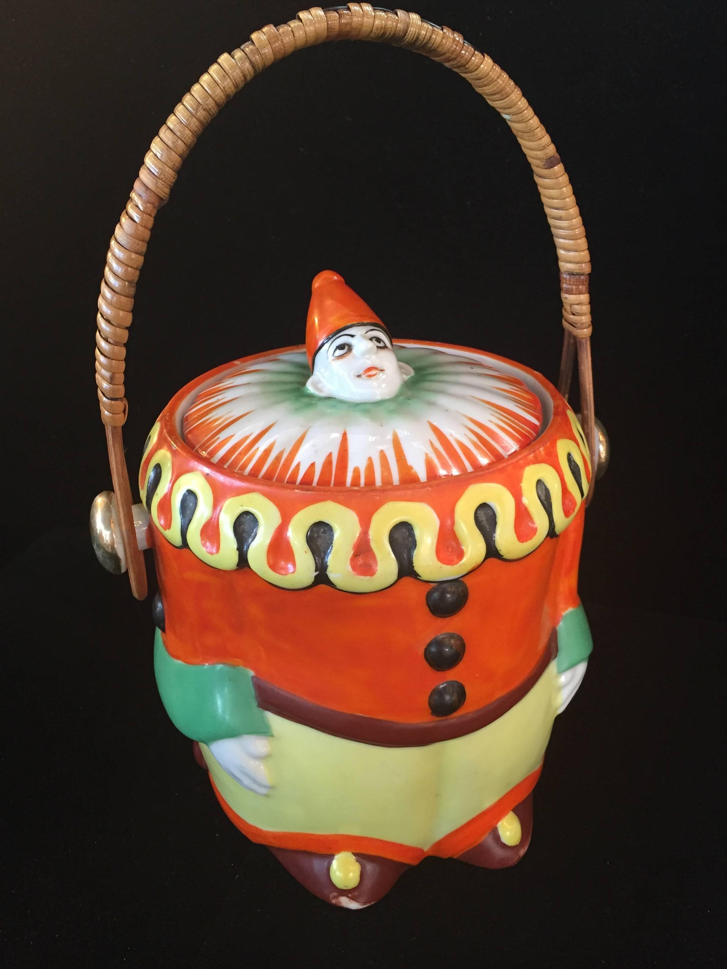 Art Deco hand-painted Pierrot cookie jar biscuit jar, stamped made in Japan, with bamboo wicker handle and gold leaf. Beautiful detail, vibrant orange black yellow green.
