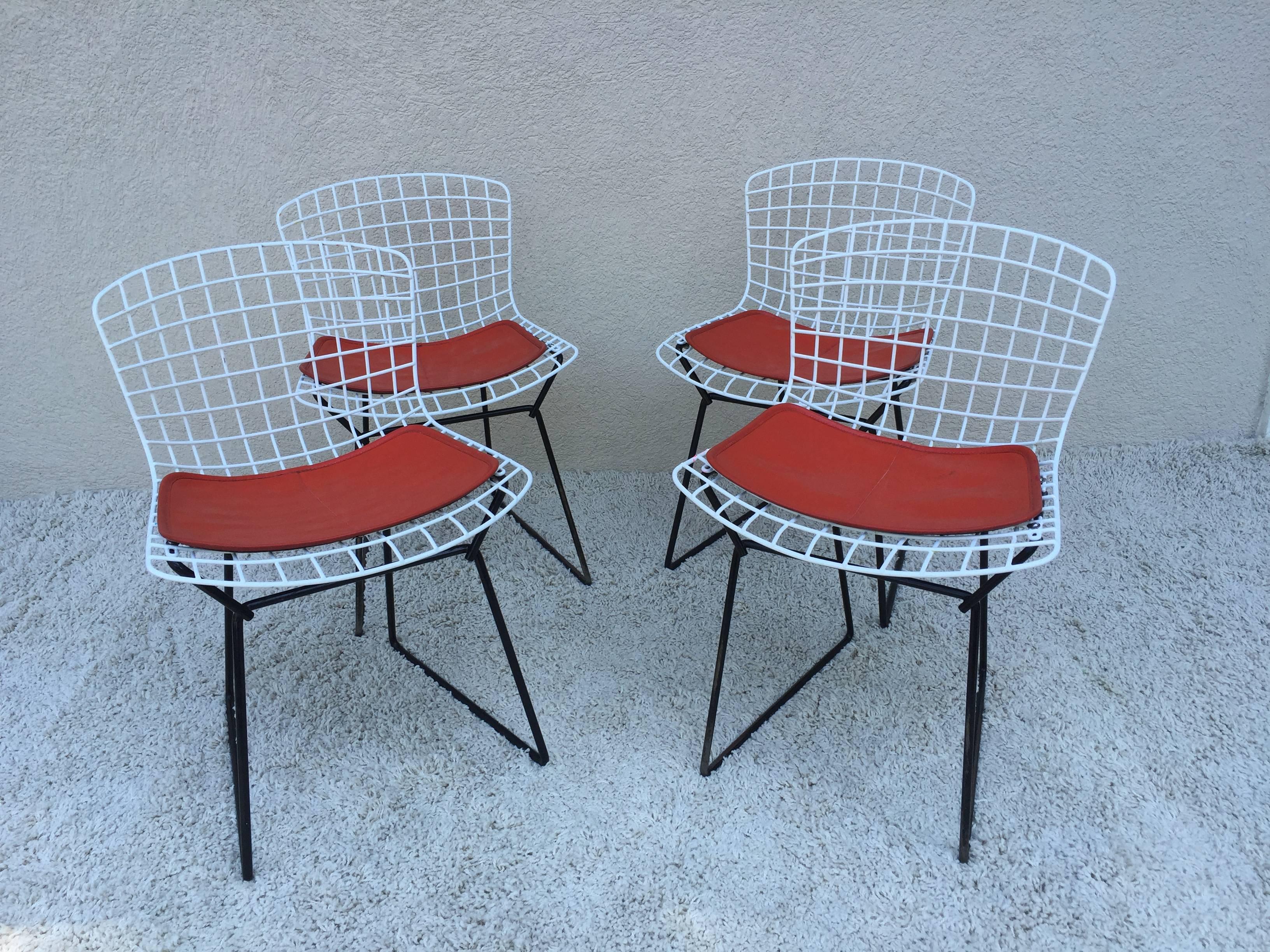 Two-six available Harry Bertoia childs chairs, white with black base, originals vintage with Knoll orange Pads, circa 1963.