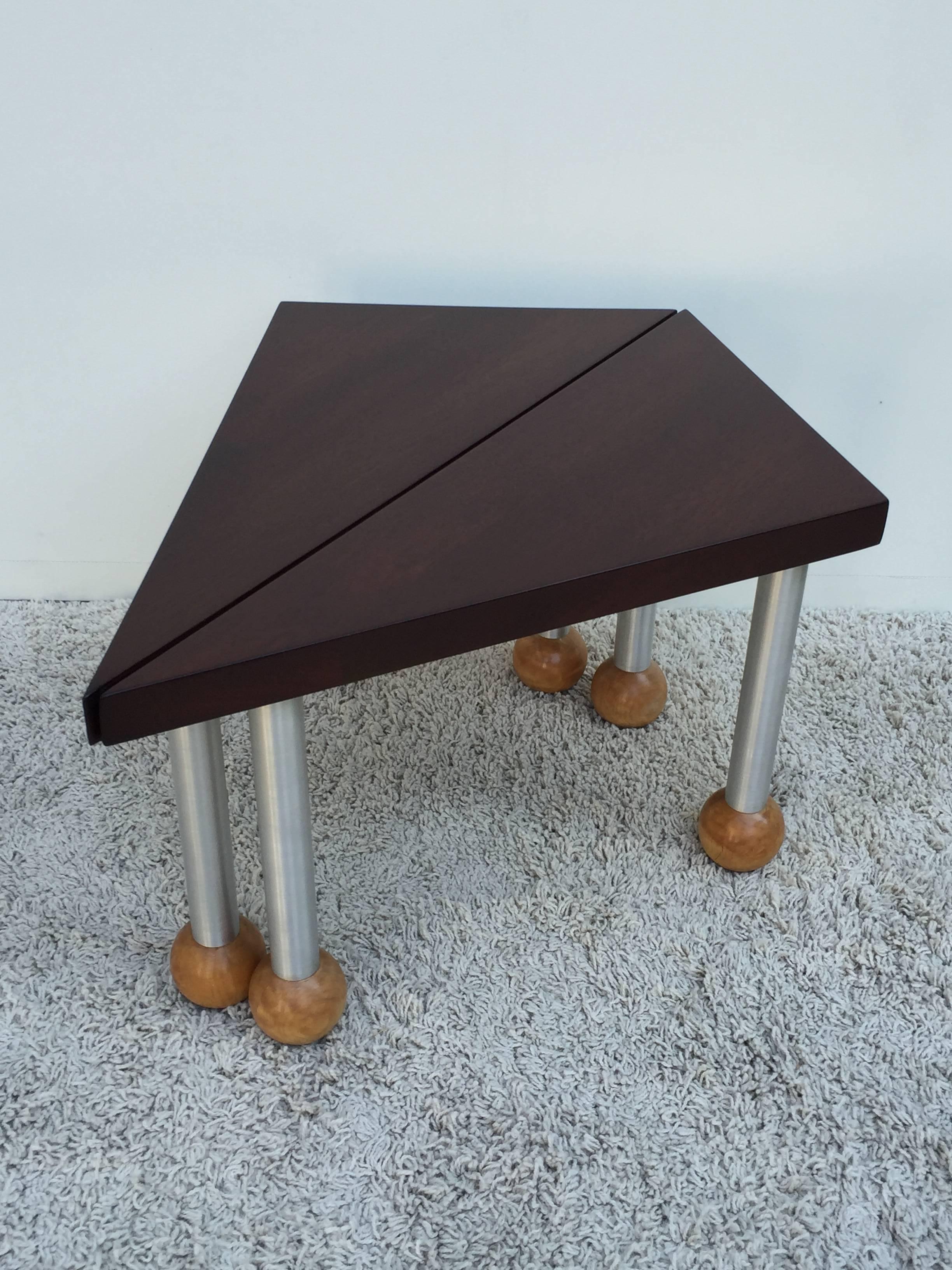 Pair of triangular shaped walnut tables, with locks to attach as one table or individual side tables, brushed aluminum legs and blonde mahogany ball feet in the style of Russel Wright. Unsigned.

Each table measures 29.50 deep 12