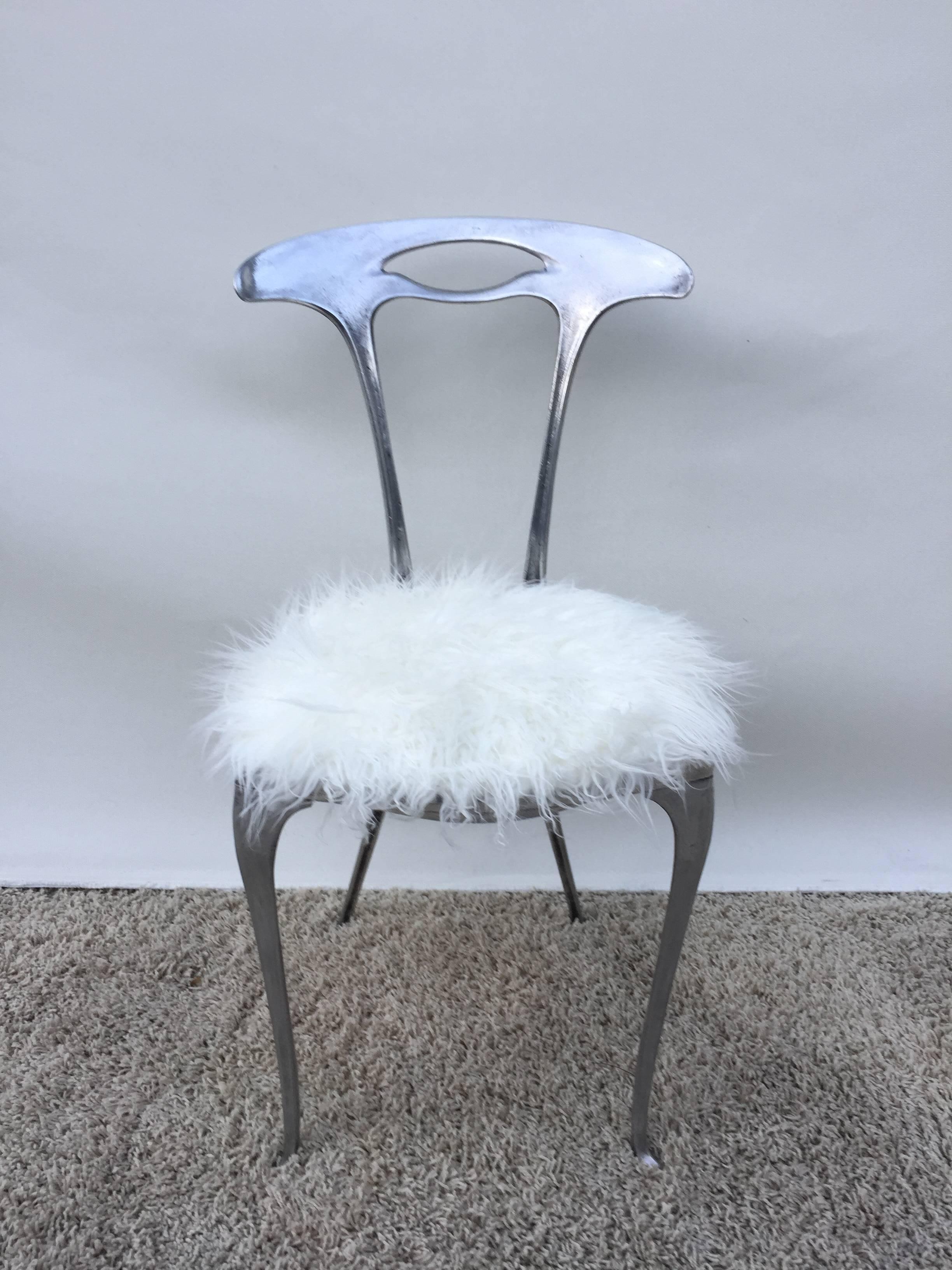 Arthur court aluminum free form petite chair with white faux fur upholstered cushion. Sleek and sophisticated design.