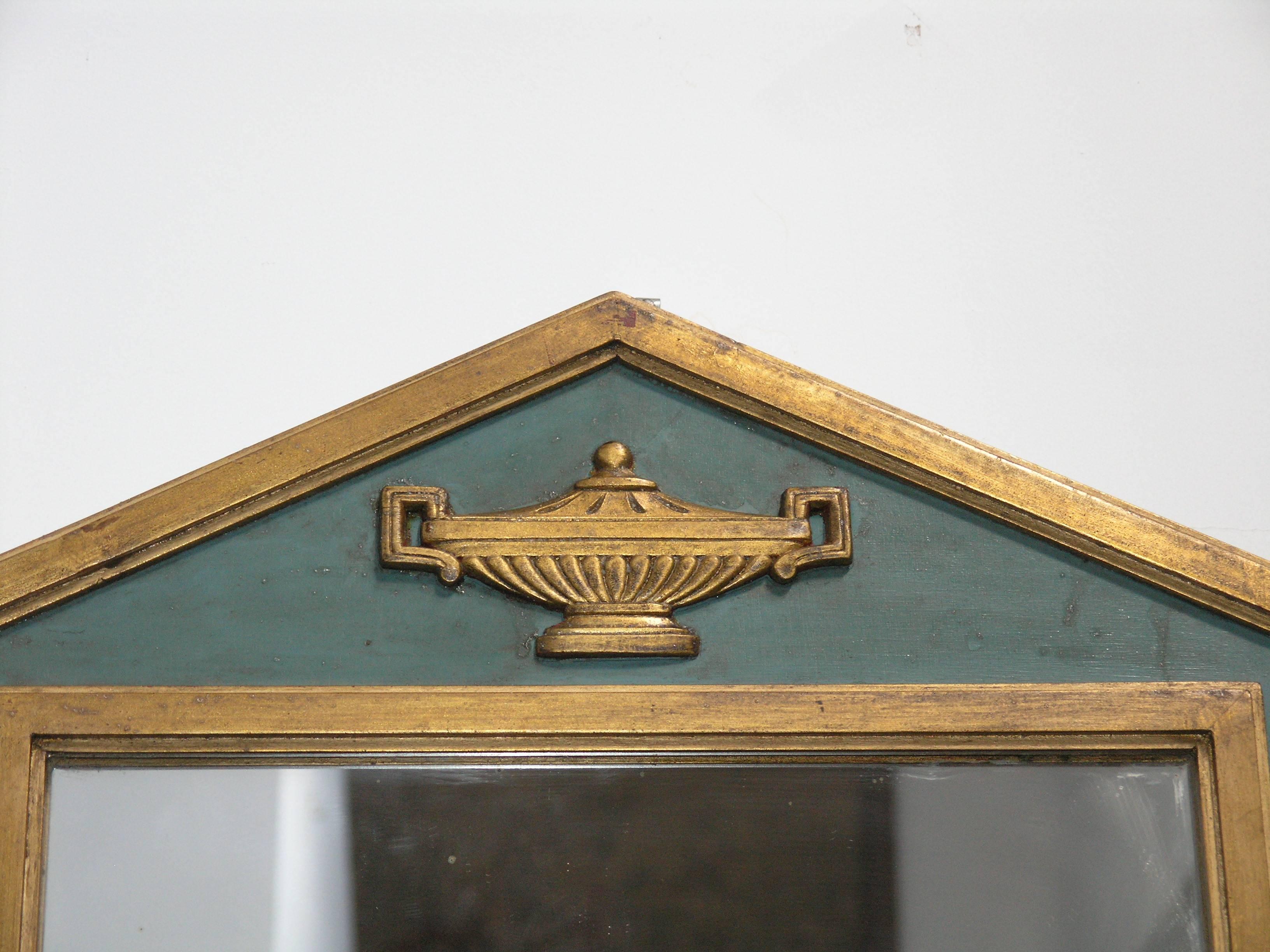 Rectangular mirror plate above a giltwood urn, all within a parcel-gilt and painted frame.