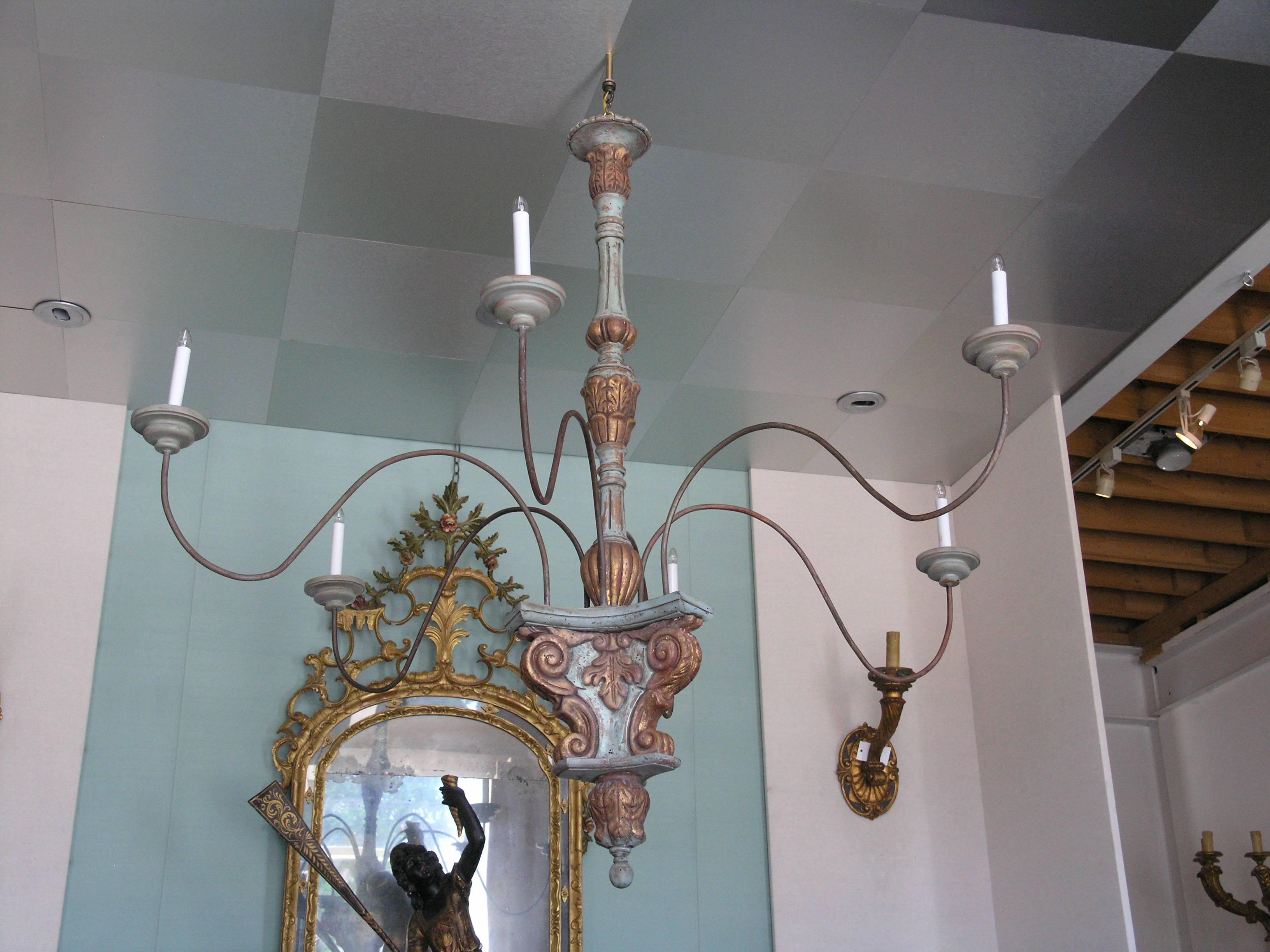 Painted Tuscan chandeliers composed of 19th century and later elements.
each with leaf carved baluster standards issuing six tole scrolling arms on tripartite bases 