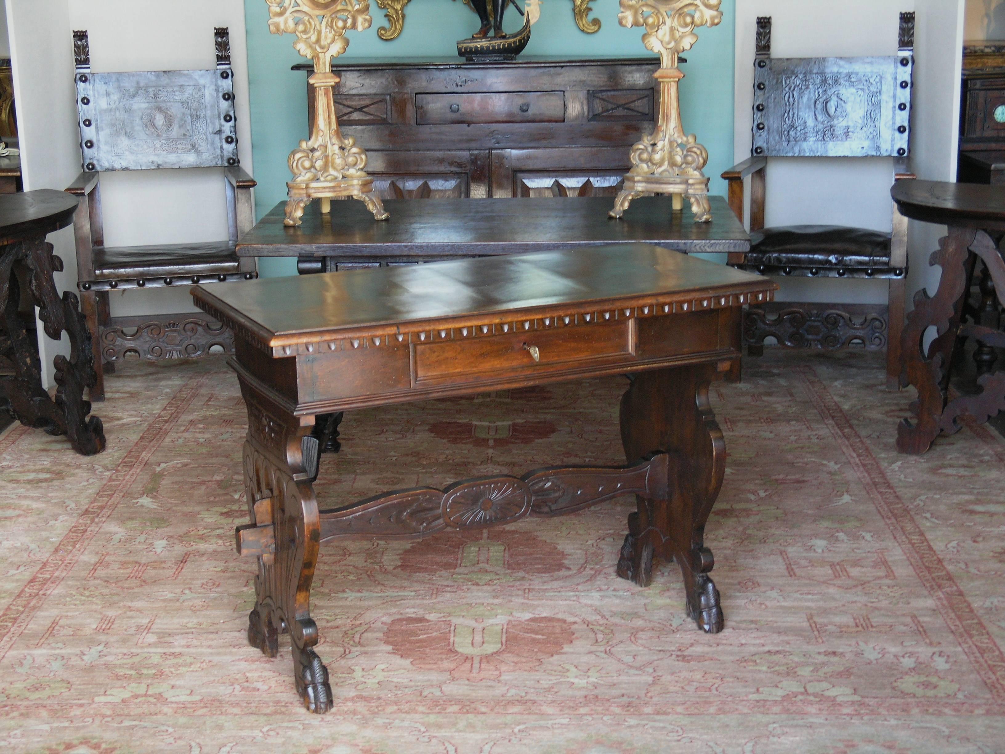 The rectangular top with molded edge above a drawer and raised on shaped end supports joined by a scroll and flowerhead decorated stretcher ending in paw feet.