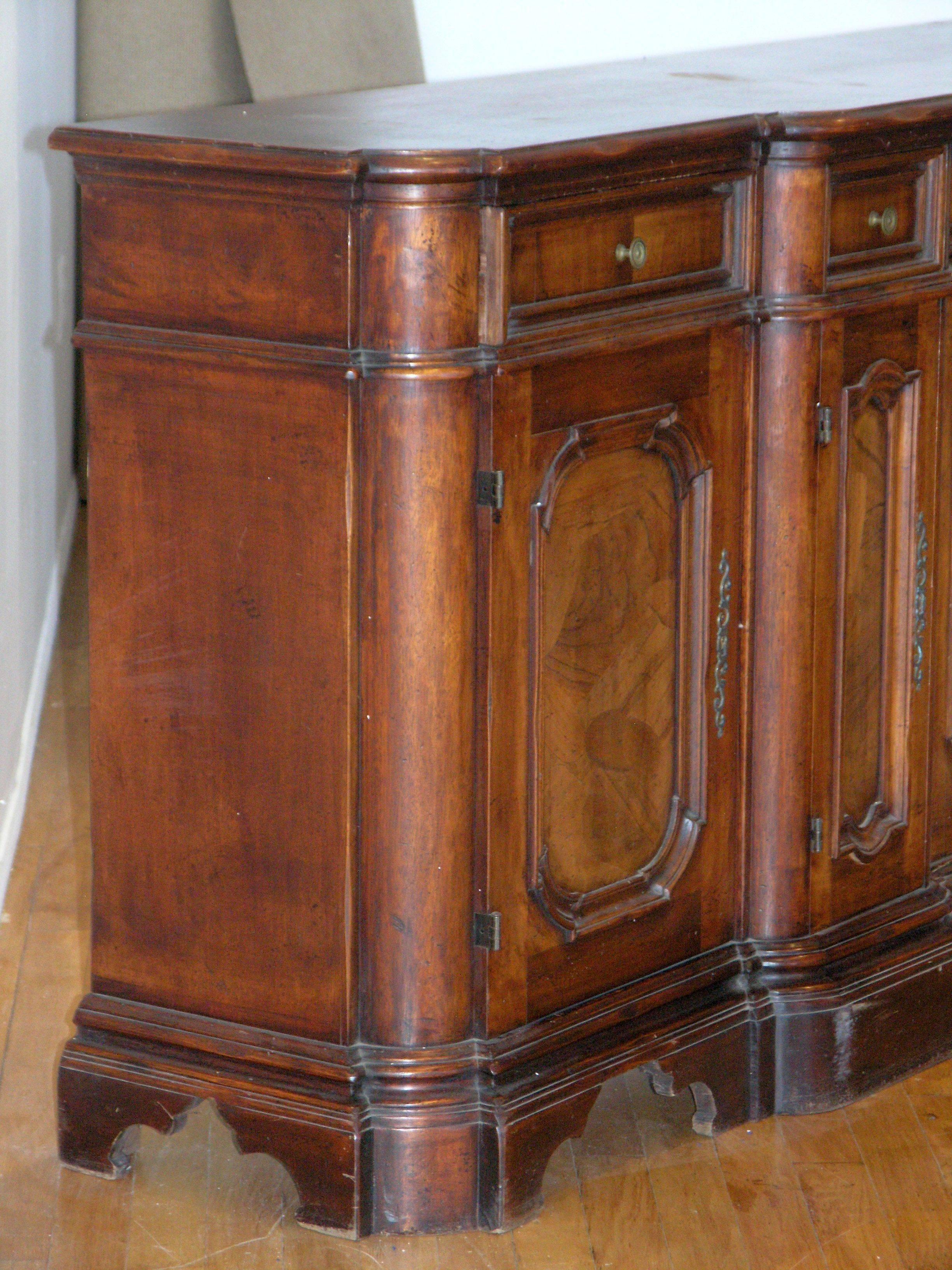 Rectangular top of bowed and broken outline with molded edge, fitted with six frieze drawers above six enclosed cupboards, on molded base with scrolled bracket feet.