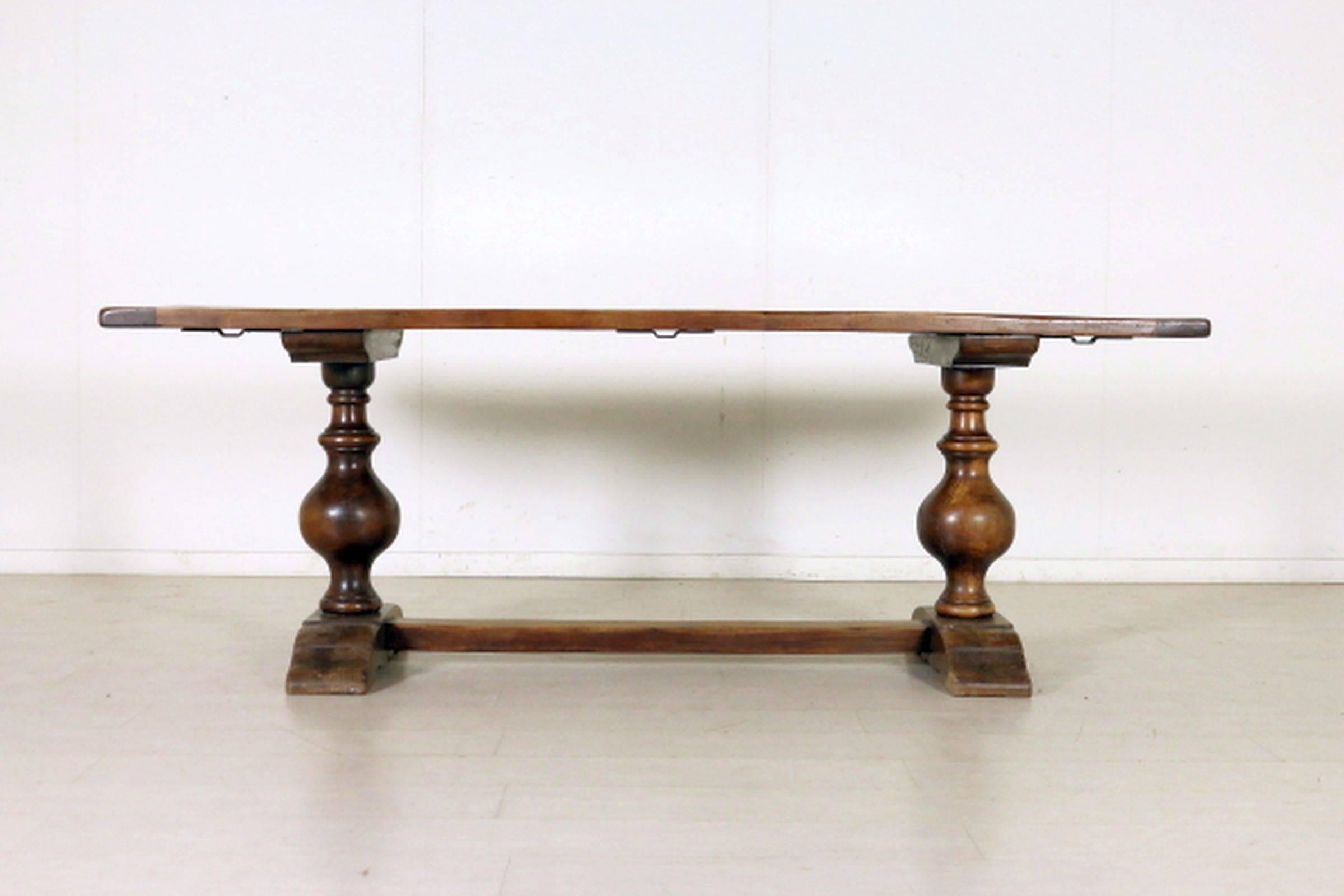 The rectangular top raised on baluster supports joined by a stretcher and ending in spreading splayed feet.