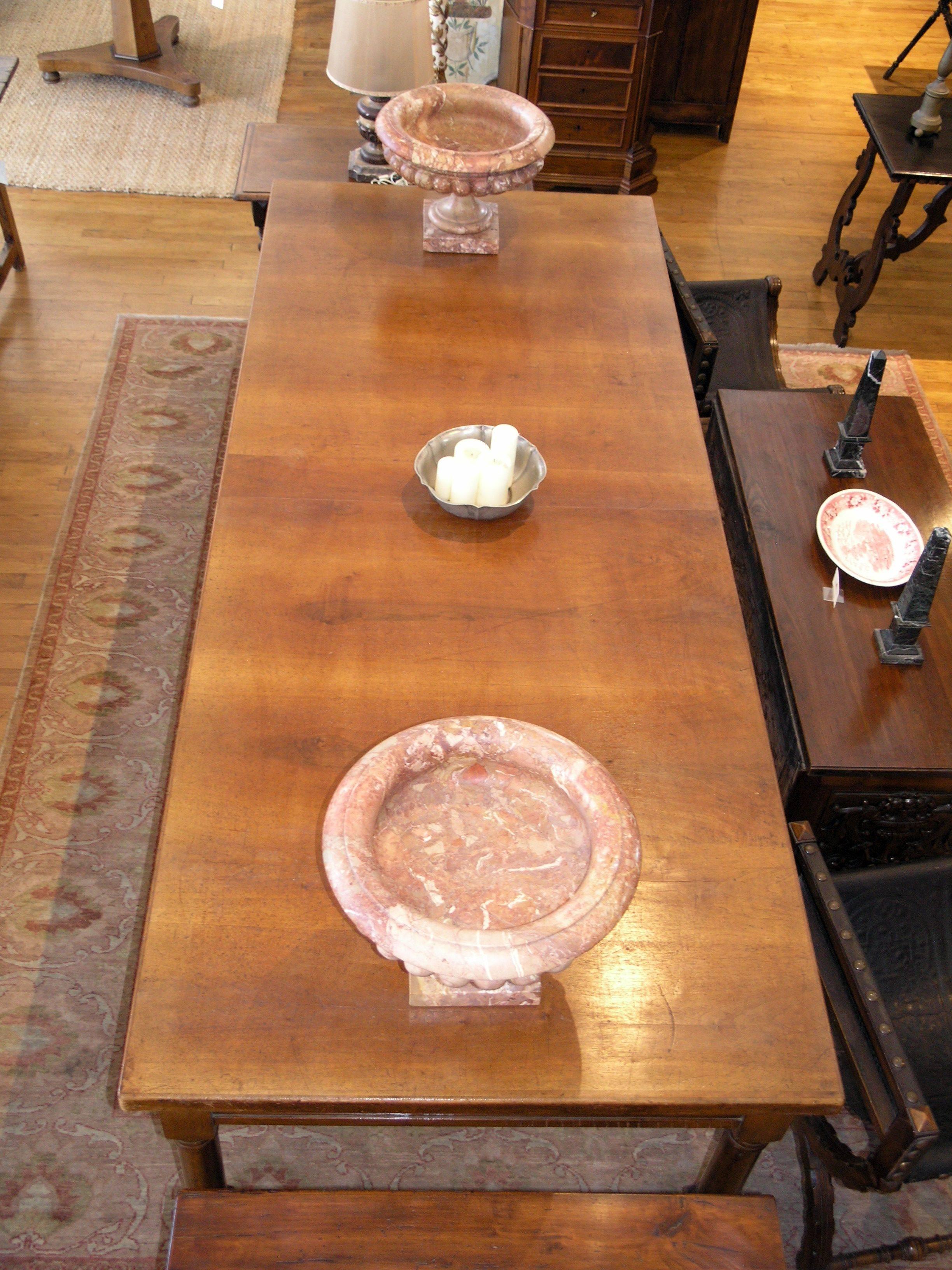 Rectangular walnut top over two frieze drawers, raised on baluster legs joined by stretchers terminating on bun feet.