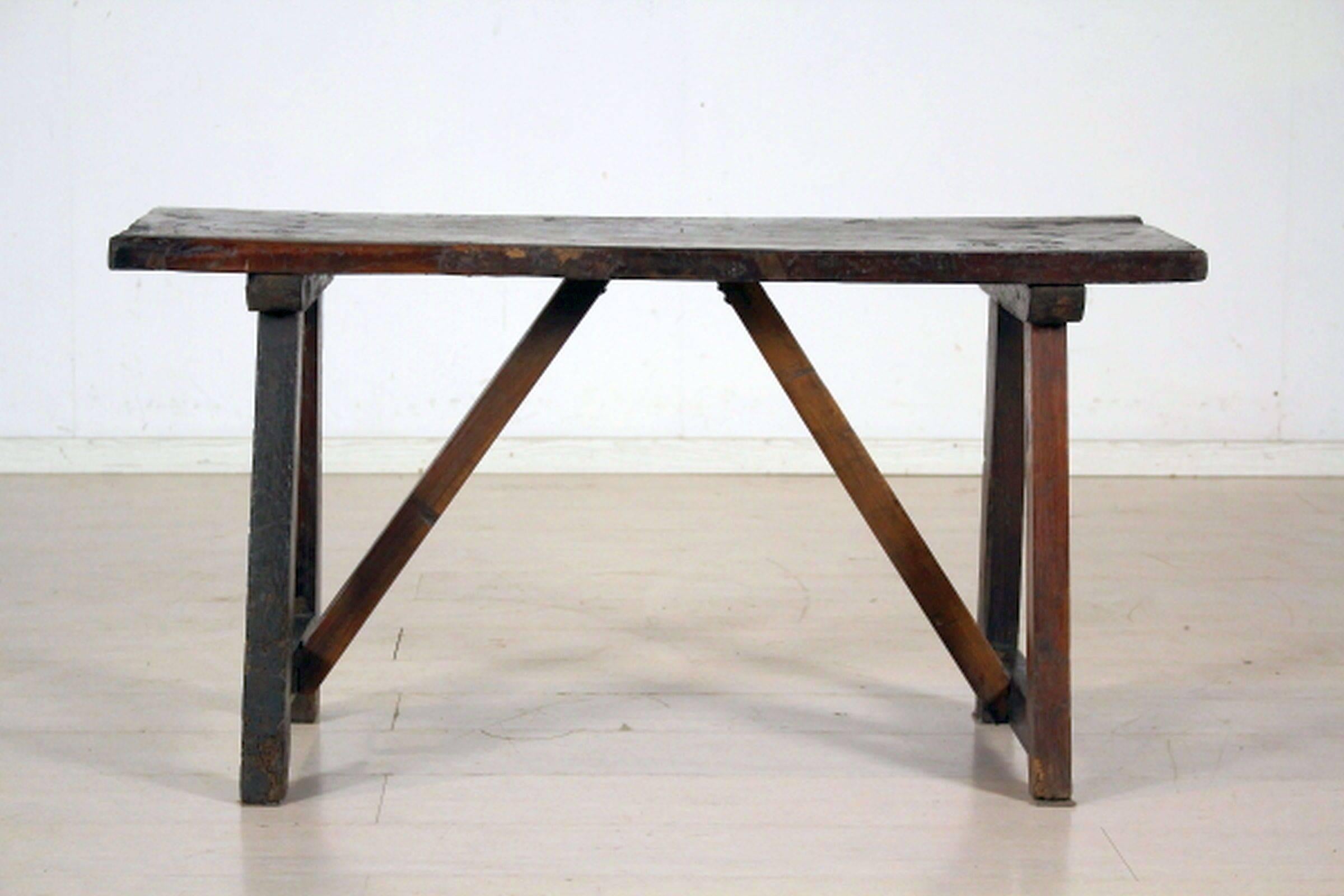 Rectangular walnut top raised on trestles joined by stretchers.