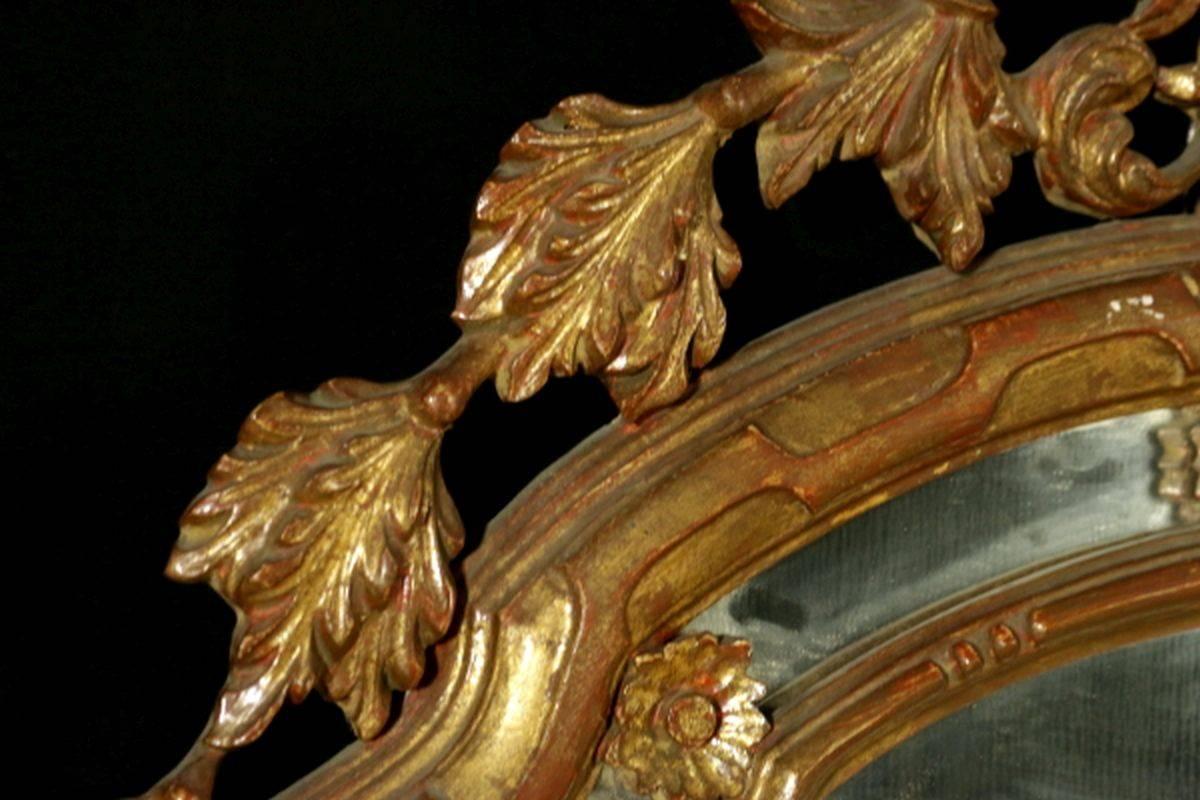The arched plate within marginal borders and surmounted by a pierced foliate cresting leading to similar pendants.