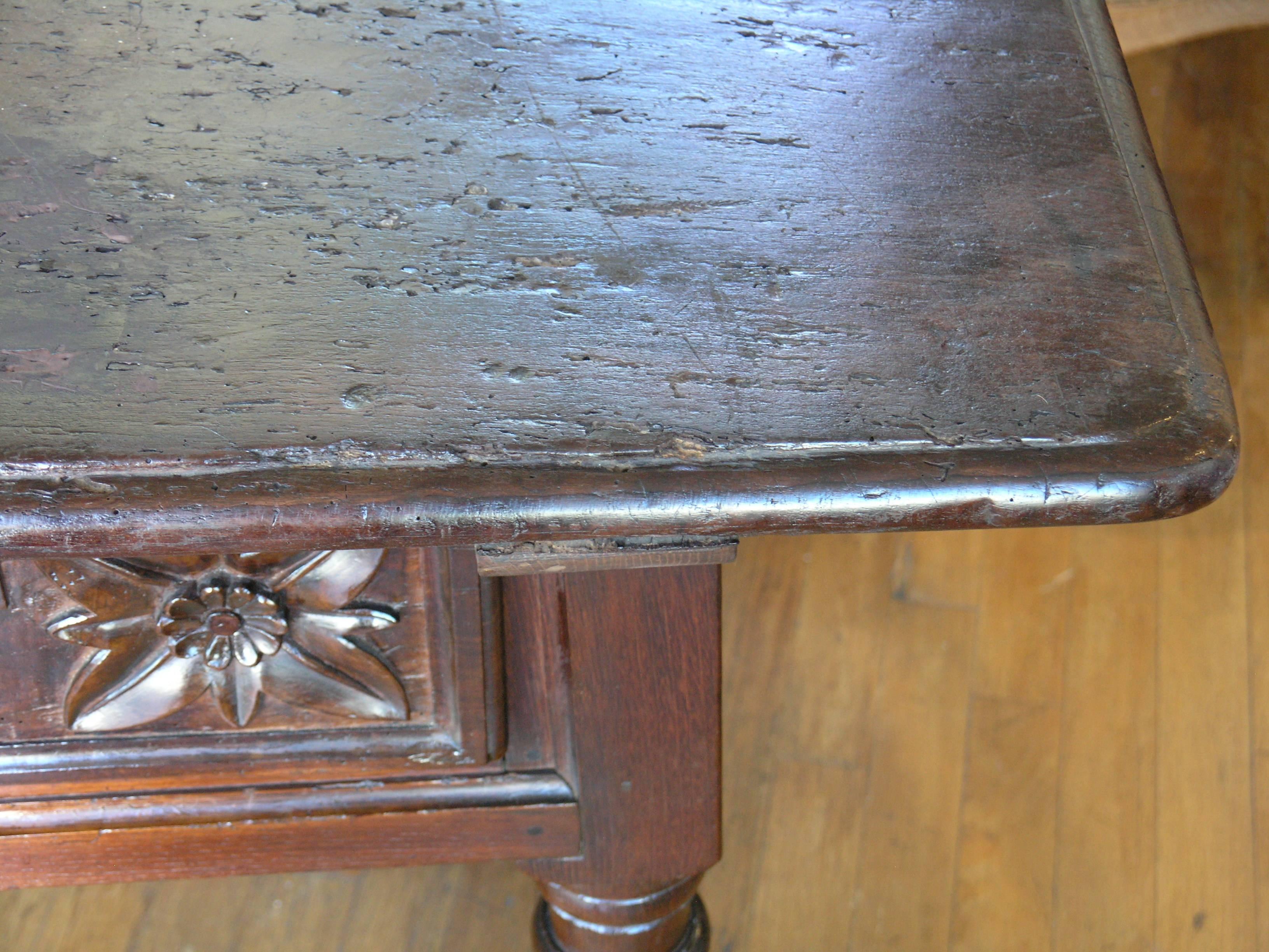 Rectangular top above three incised carved drawers raised on baluster legs joined by stretchers.