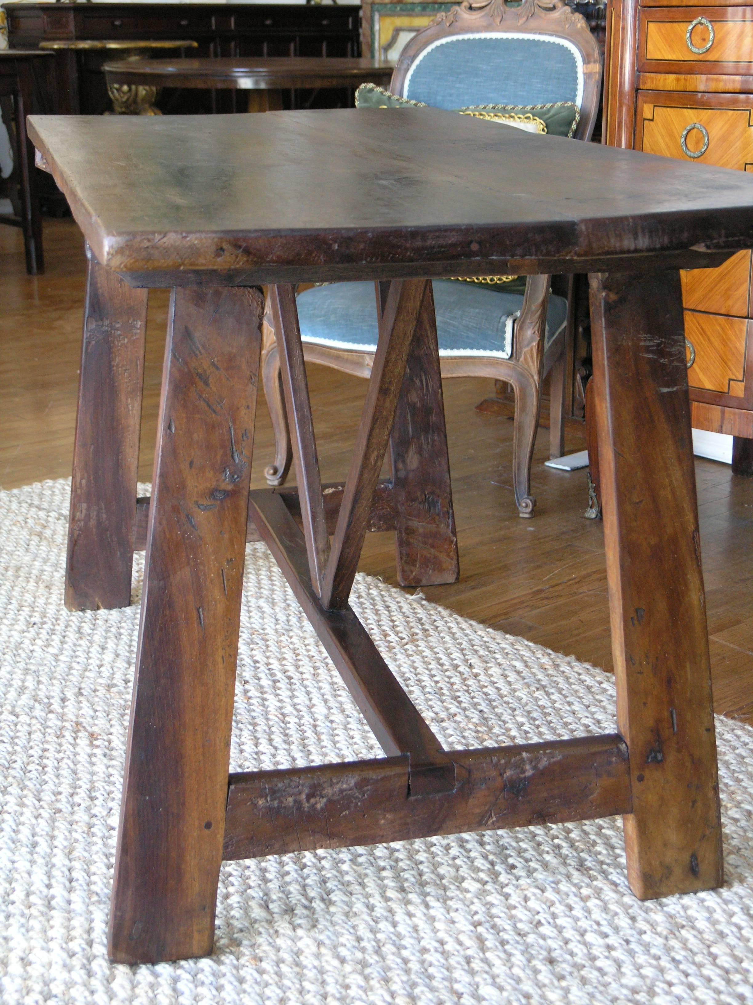 Rectangular walnut top raised on trestles joined by stretchers.