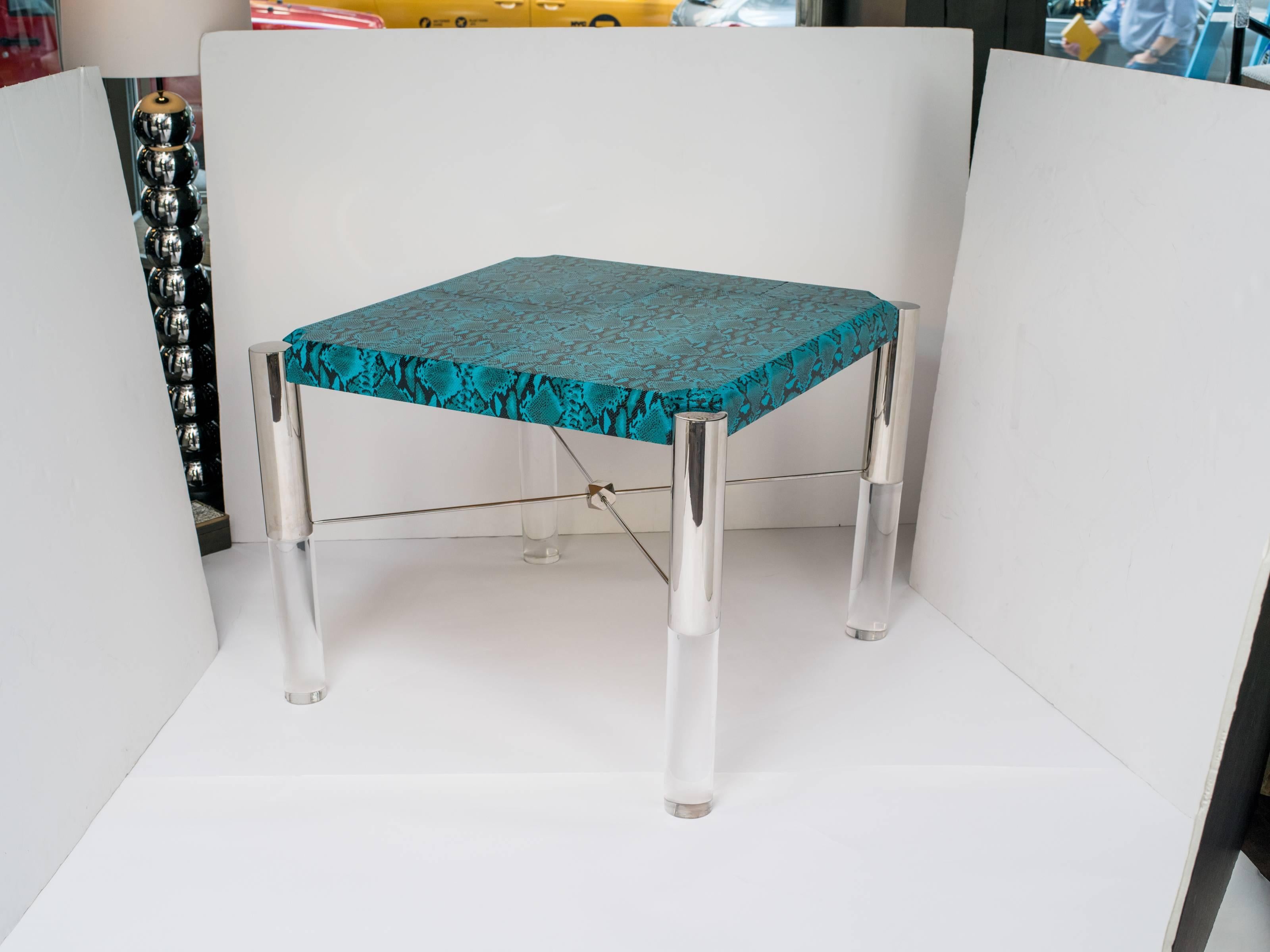Stunning mid-century modern game table in vibrant turquoise leather with embossed faux python. Square table with shield top design. Cylinder legs are comprised of gunmetal finish and solid lucite. Fitted with X base crossbars held by a geometric