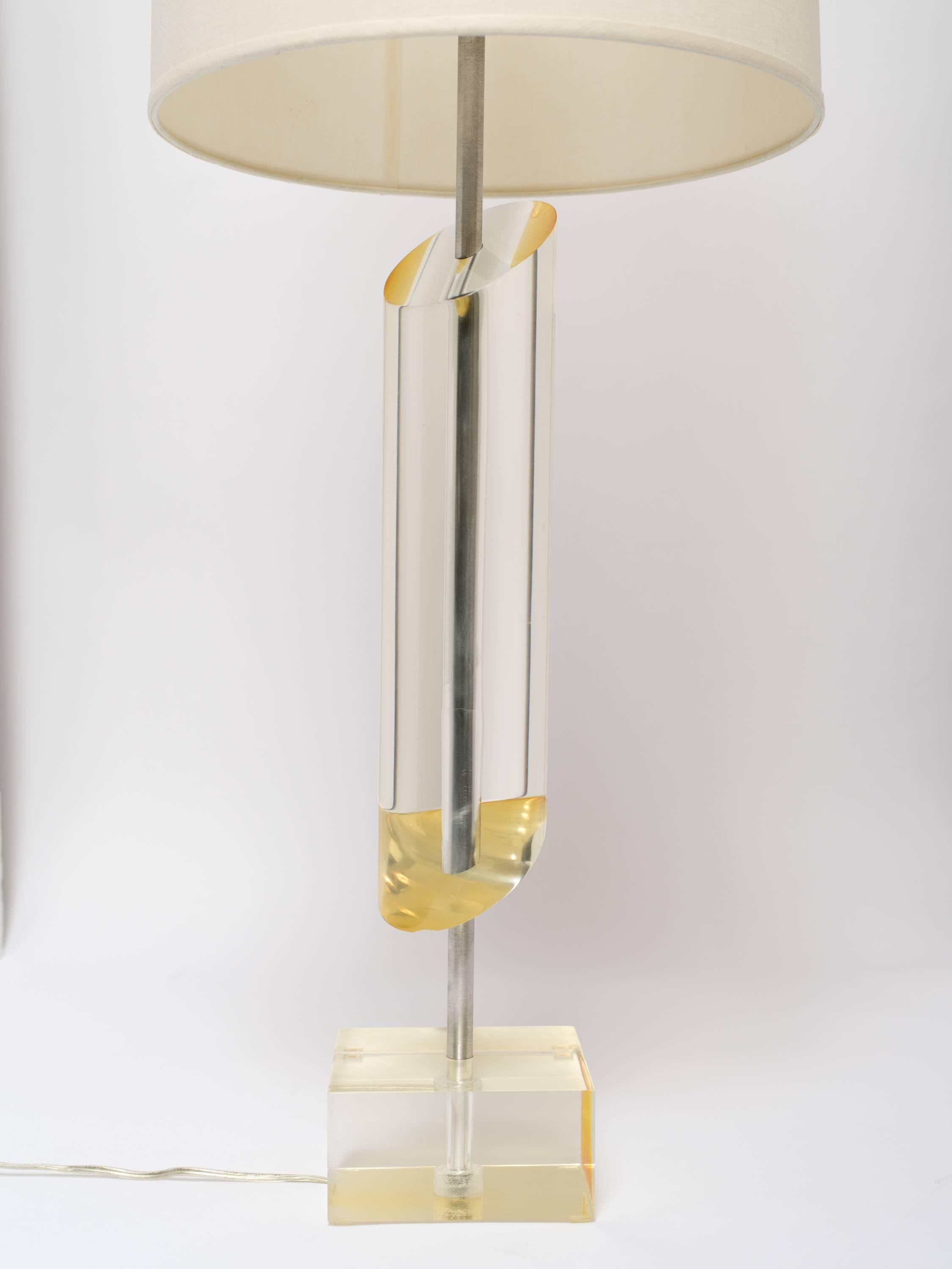 Sculptural mid-century modern lamp with slanted column design. Lamp is comprised of solid lucite cylinder with asymmetrical design and heavyset lucite base.  Lucite has amber or golden undertones and is fitted with and two lights, featuring on/off