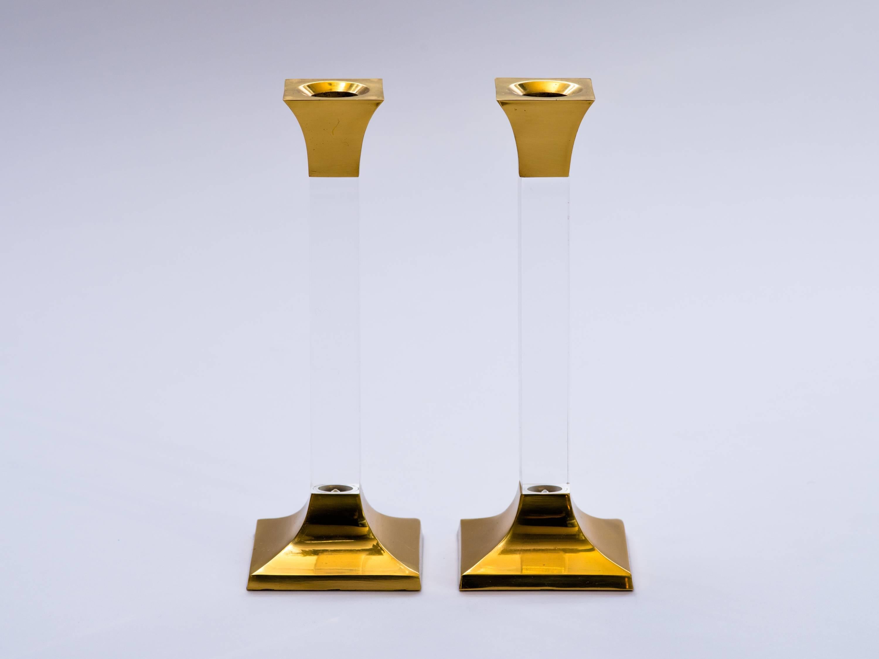 Pair of chic Mid-Century Modern candlesticks with plinth column design. Comprised of brass metal bases with polished lucite stems. 