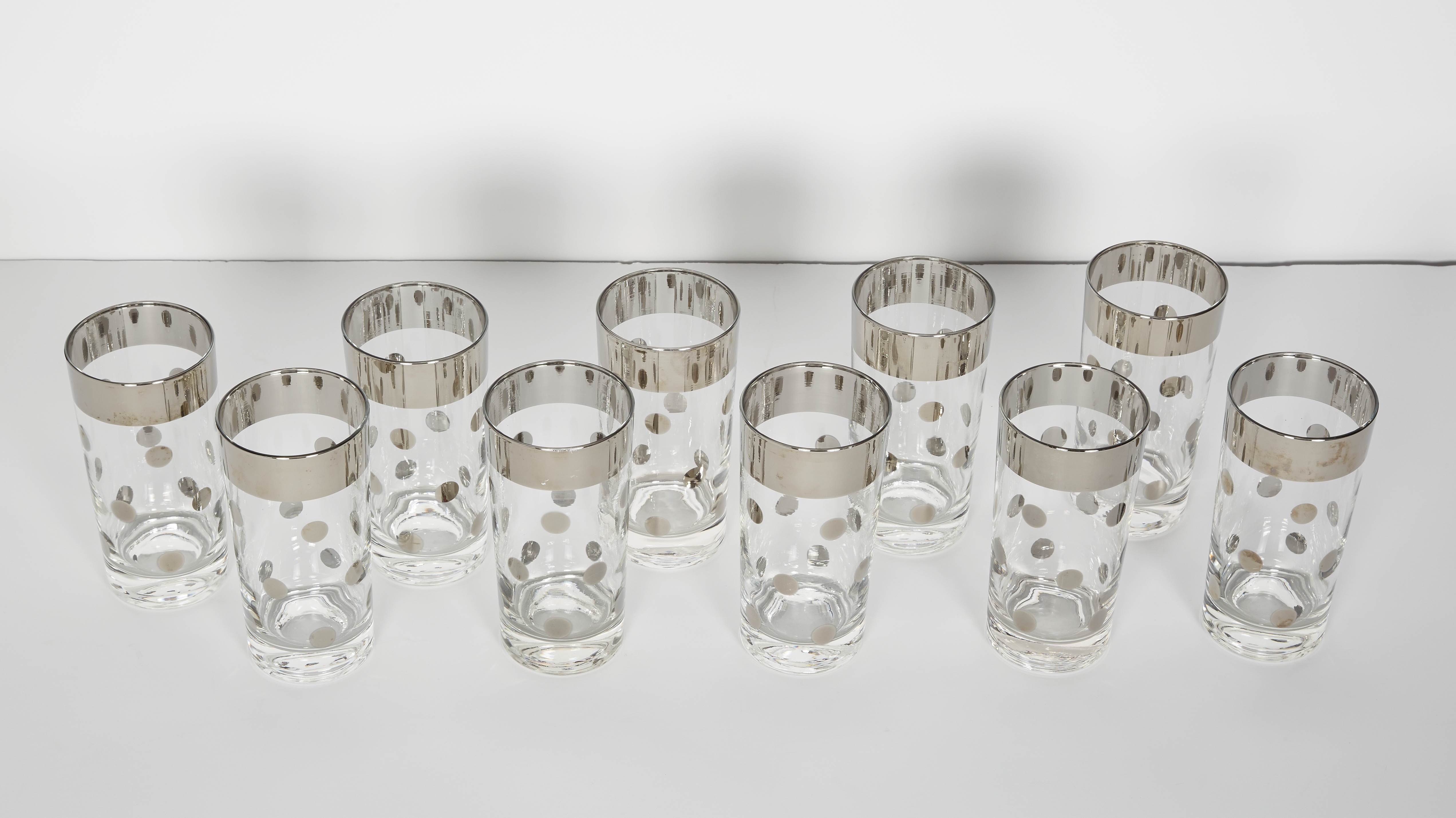 Set of Mid-Century Modern cocktail glasses consisting of ten tall Tumblr glasses. The glasses have a silvered gunmetal trim detail with polka dot design. Adds a smart and cheerful addition to any bar set or dinnerware set.