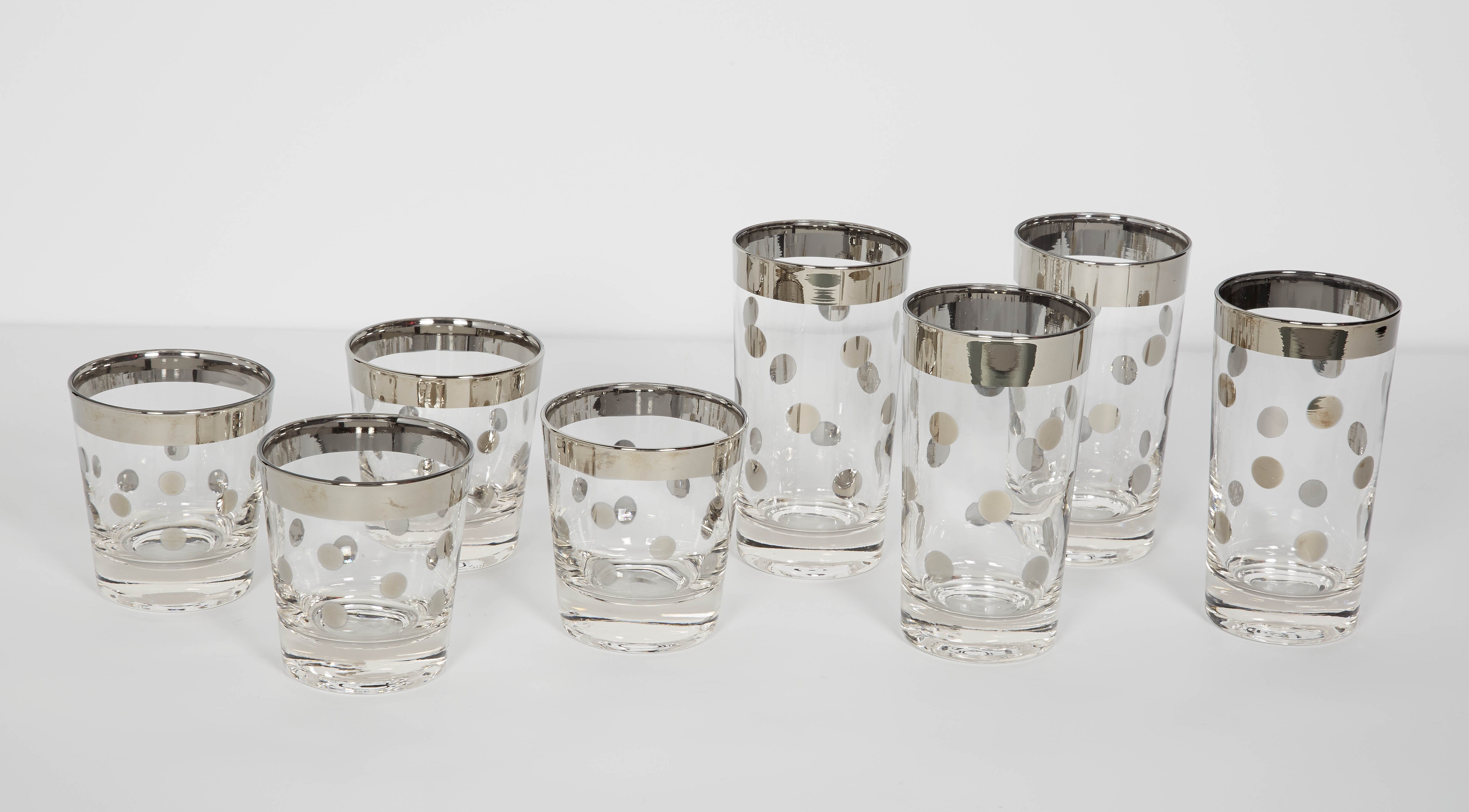 Set of Mid-Century Modern cocktail glasses includes four highball glasses and four rock glasses. The glasses have a chic silvered gunmetal trim detail with polka dot design. Makes a smart and fun addition to any bar set or serving