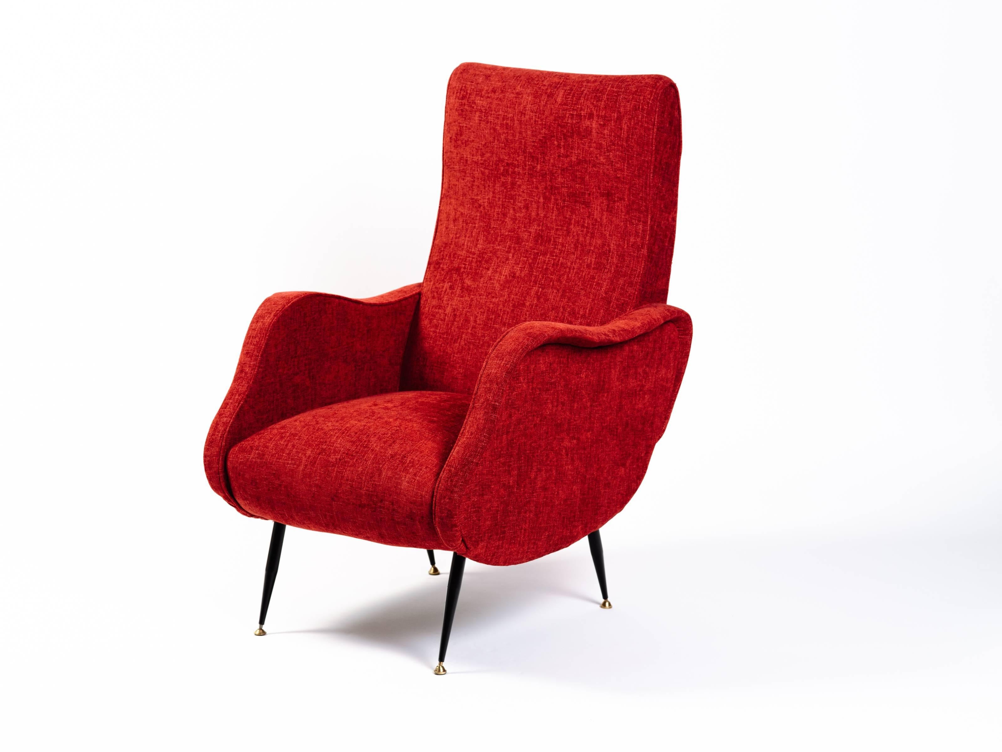 Iconic Italian Mid-Century Modern lounge chair in the style of Marco Zanuso, upholstered in vibrant woven red. Chair features slightly reclined back with kidney shaped sides. The chair has narrow splayed legs in black enameled metal with brass