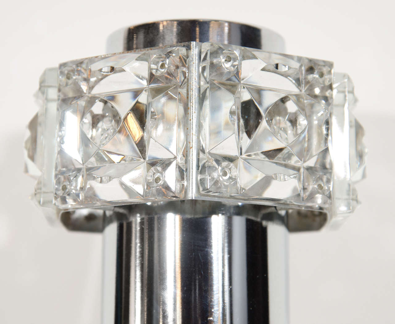 Gorgeous Austrian Mid-Century Modern sconce with barbell form. The sconce has a chrome frame with cut crystal faceted glass details. The sconce is fitted with two lights, one uplight and one downlight. While illuminated the sconce also casts light