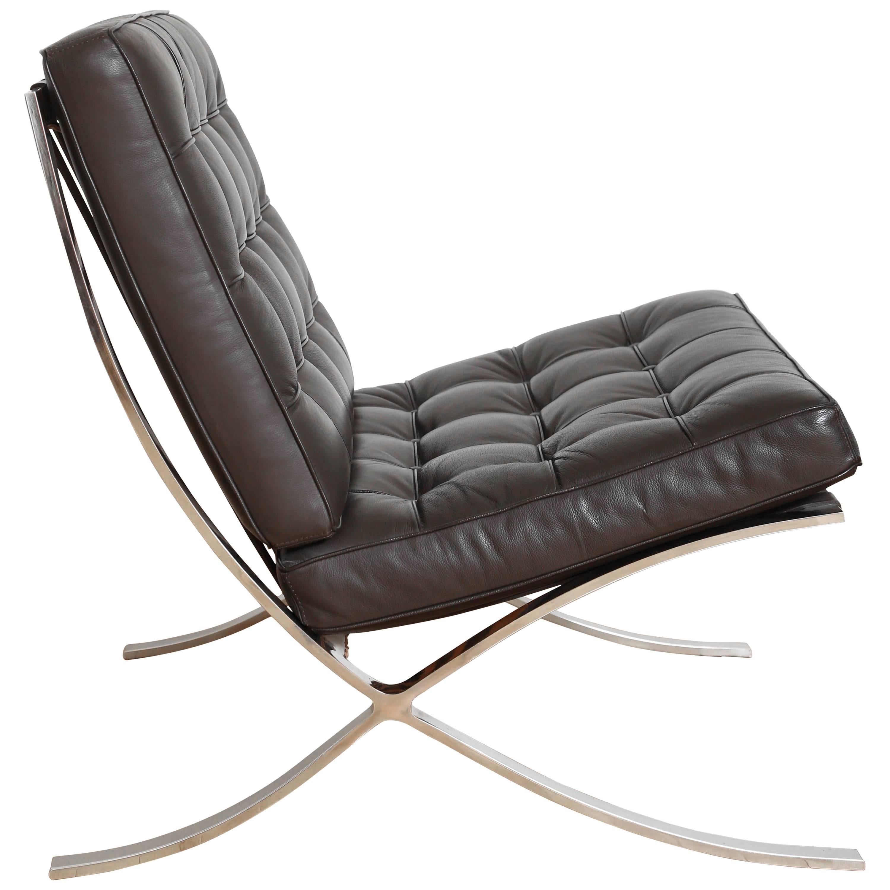 Vintage Barcelona lounge chair in espresso brown leather. Iconic design originally manufactured during the Bauhaus Movement, circa 1929. The chair has a slight recline, and features leather slats along the back with tufted seat cushions. Suited for