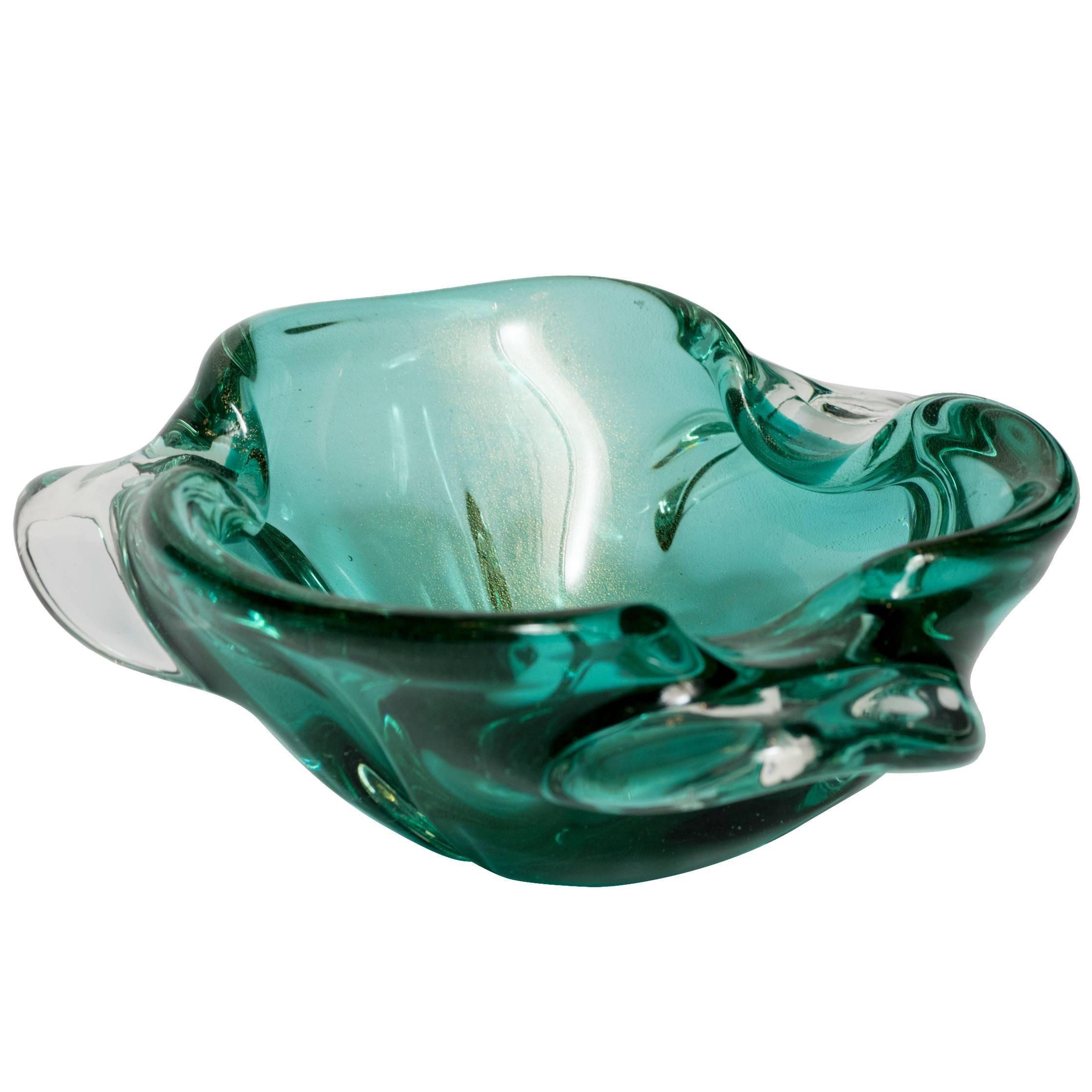 Italian Mid-Century Modern glass bowl or ashtray with organic form. Comprised of hand blown Murano glass in hues of emerald green with gold fleck details. Beautiful from every angle, the bowl features pinched rim design with trilateral winged sides.