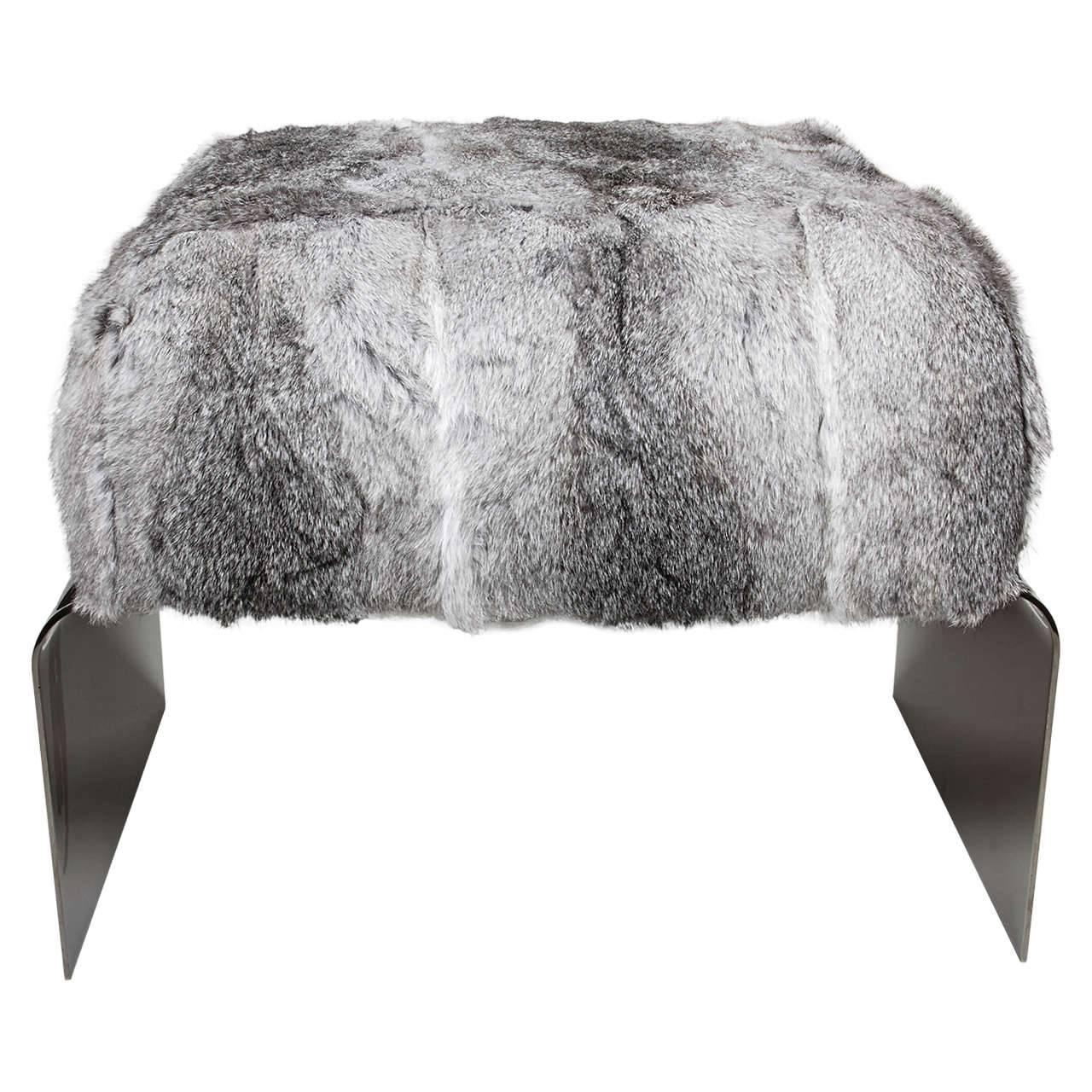 Mid-Century Modern style stool with streamlined waterfall base design in polished black nickel. The bench is upholstered in luxurious rabbit fur in variant hues of grey. Great accent piece for any room and also great as an ottoman.